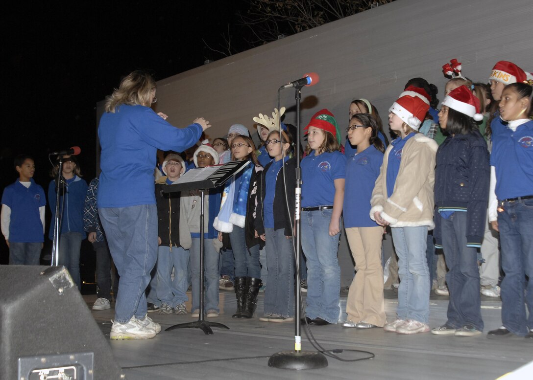 Sheppard Elementary students perform Dec. 2 to light up the holiday tree near Sheppard's Commissary. Brig. Gen. O.G. Mannon, 82nd Training Wing commander, and Col. Daniel Torweihe, 80th Flying Training Wing vice commander, were on hand to help usher in the holiday season. (U.S. Air Force photo/Lou Anne Sledge)