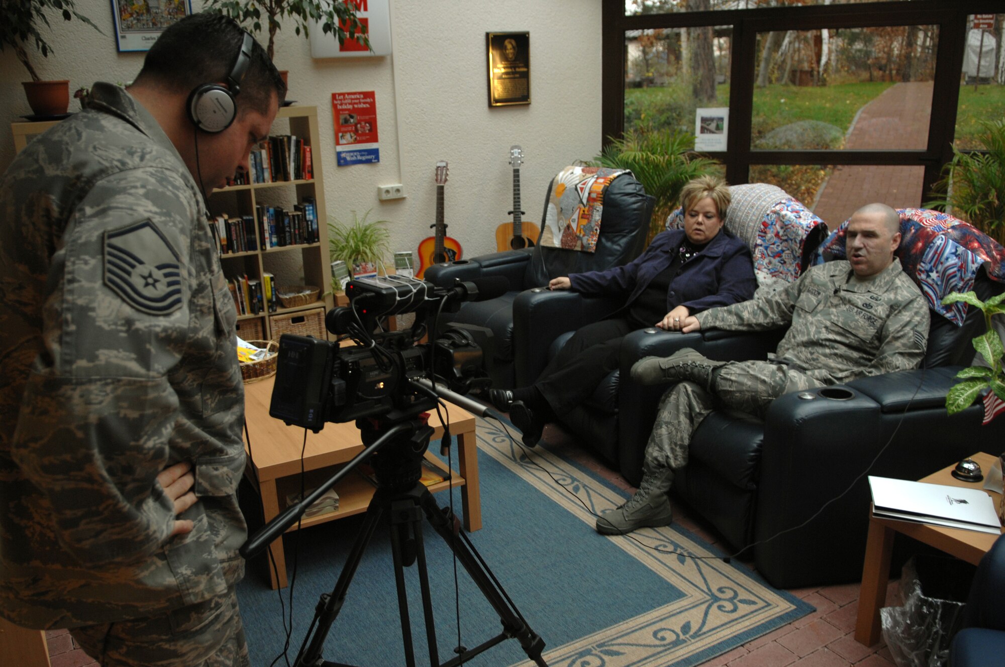 Master Sgt. Christopher Stone, Air Force News video broadcaster, shoots a commercial of Staff Sgt. Matthew Slaydon and his wife, Annette, discussing the importance of completing pre-deployment paperwork prior to deployment, Ramstein Air Base, Germany, Nov. 21, 2008. Sgt. Slaydon was severely injured in Iraq 13 months ago during a deployment there as an explosive ordinance disposal technician and is visiting Ramstein as part of a morale tour, following his recovery. (U.S. Air Force photo by Airman 1st Class Tony R. Ritter)