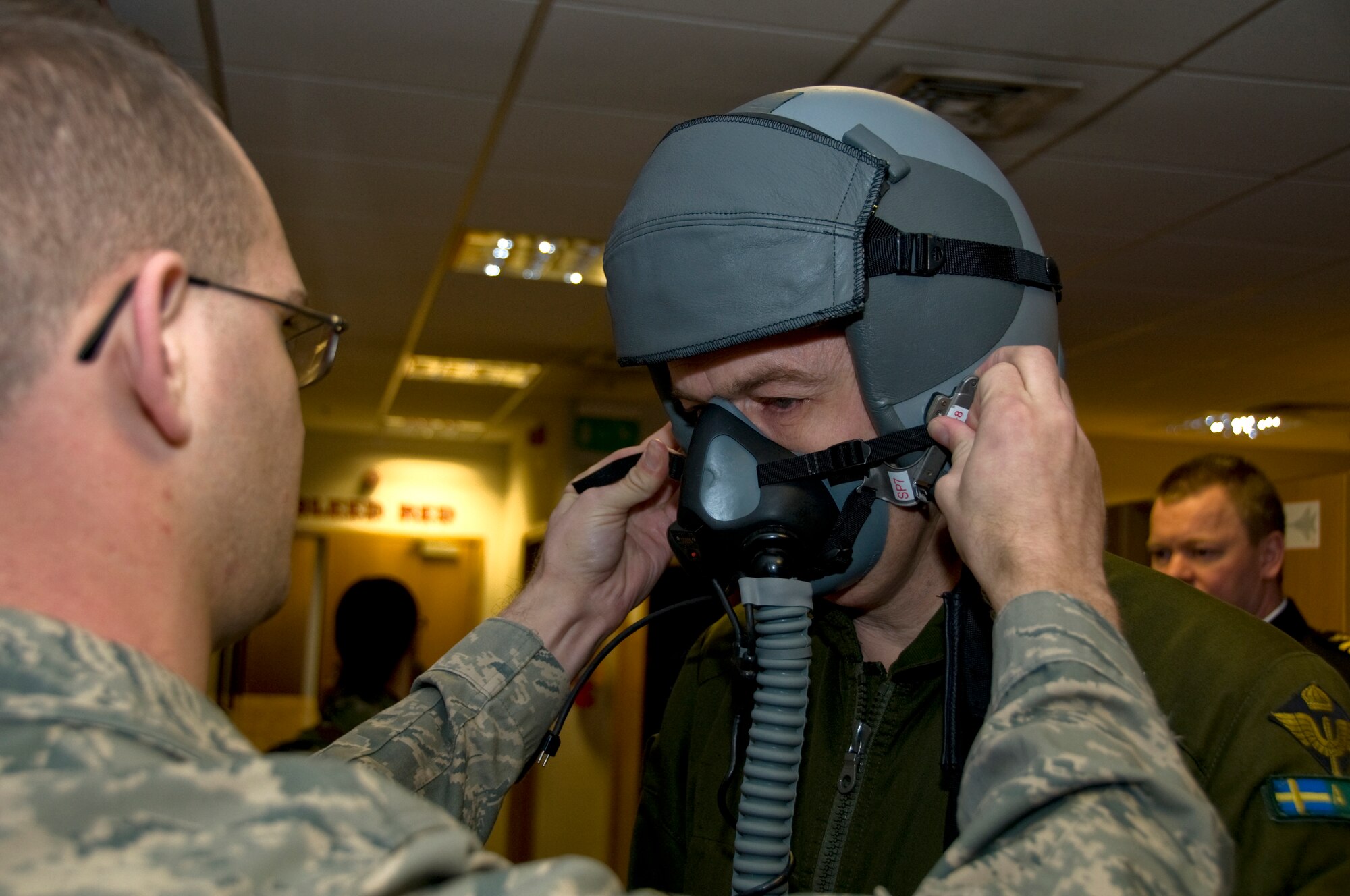Staff Sgt. Micah Muscott, 49th Operations Support Squadron, helps Maj. Gen. Anders Silwer, Swedish Air Force Chief of Staff, with helmet adjustments Dec. 1 at RAF Lakenheath, England. Members of the Swedish Air Force were invited to Lakenheath to build professional and personal relationships with Swedish Air Force Senior Leaders. (U.S. Air Force photo by Airman 1st Class Perry Aston)