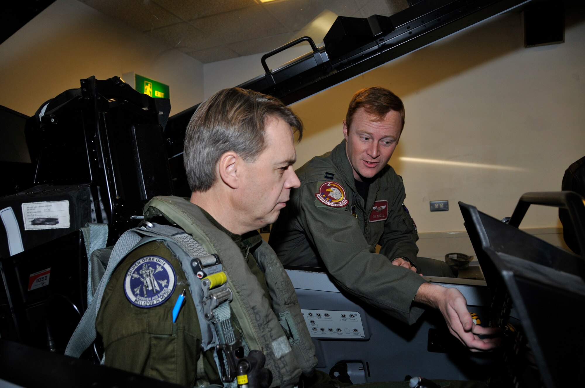 Capt. Timothy Tendall, 492nd Fighter Squadron, shows Maj. Gen. Anders Silwer, Swedish Air Force Chief of Staff the location of the menu buttons for the displays Dec. 1 at RAF Lakenheath, England. Members of the Swedish Air Force were invited to Lakenheath to build professional and personal relationships with Swedish Air Force Senior Leaders. (U.S. Air Force photo by Airman 1st Class Perry Aston)