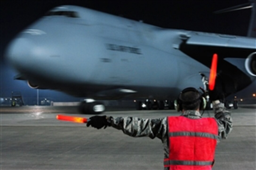 U.S. Air Force Staff Sgt. Michael Sligh marshals a C-5 Galaxy on Joint Base Balad, Iraq, Nov. 22, 2008. Sligh, a guidance, control and avionics technician, is assigned to the 521st Aircraft Mobility Operations Group Detachment 5.