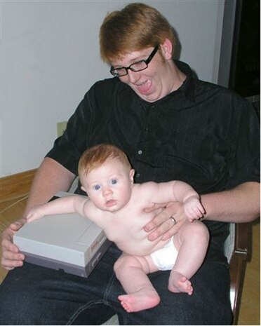 Allan Desruisseaux plays with his infant son, Michael, before he chose to enlist in the Marine Corps. Lance Cpl. Desruisseaux lost more than 100 pounds, down from his initial weight of 326 pounds, to enlist in the Corps. He now serves with Provisional Rifle Platoon 3, Regimental Combat Team 5, and spends his off-duty time working out, maintaining a strong physique, and looking forward to reuniting with his son.