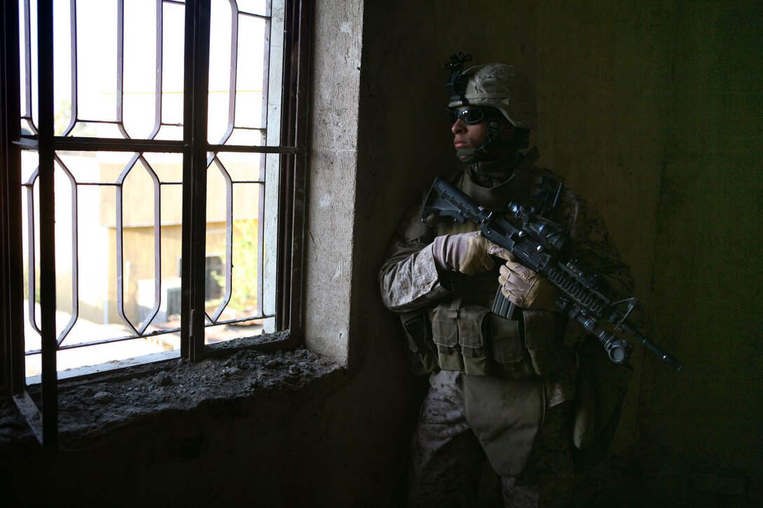 Lance Cpl. Steve Smith, a supply warehouseman with Provisional Rifle Platoon 3, Regimental Combat Team 5, keeps security while other Marines clear a house in Rawah, Iraq, Dec. 4. Smith and PRP-3 recently completed a two-month assignment as security for Traffic Control Points 3 and 4, which are on the Rawah Bridge.