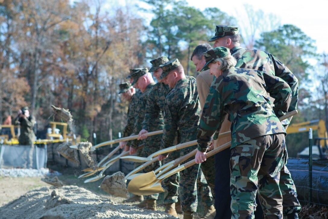 Faculty members of Field Medical Training school participate in christening the groundbreaking of their new future state-of-the-art facility, Dec. 4, at Camp Johnson, one of the Marine Corps bases Camp Lejeune. The ceremony was held to commemorate the future FMTS building, which would facilitate students, faculty and up to date equipment to better educate sailors in treating wounded Marines in today's combat warfare.