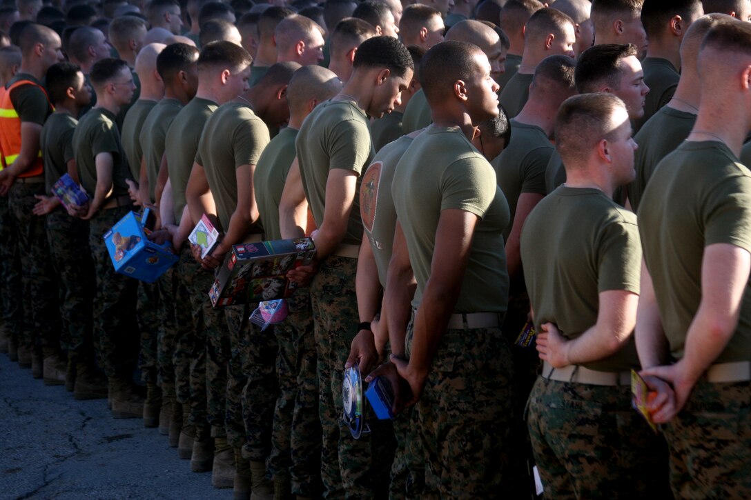 MCCES Marines stand in formation while holding their toys to donate before the 13th annual MCCES Toys for Tots Run aboard the Combat Center Dec. 5.