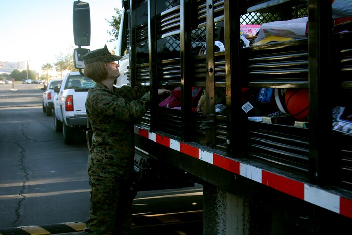 A Marine readjusts toys donated by MCCES Marines in the back of a flat bed truck during the 13th annual MCCES Toys for Tots Run aboard the Combat Center Dec. 5.  The total donation from MCCES Marines this year was between 1,100 and 1,200 toys.