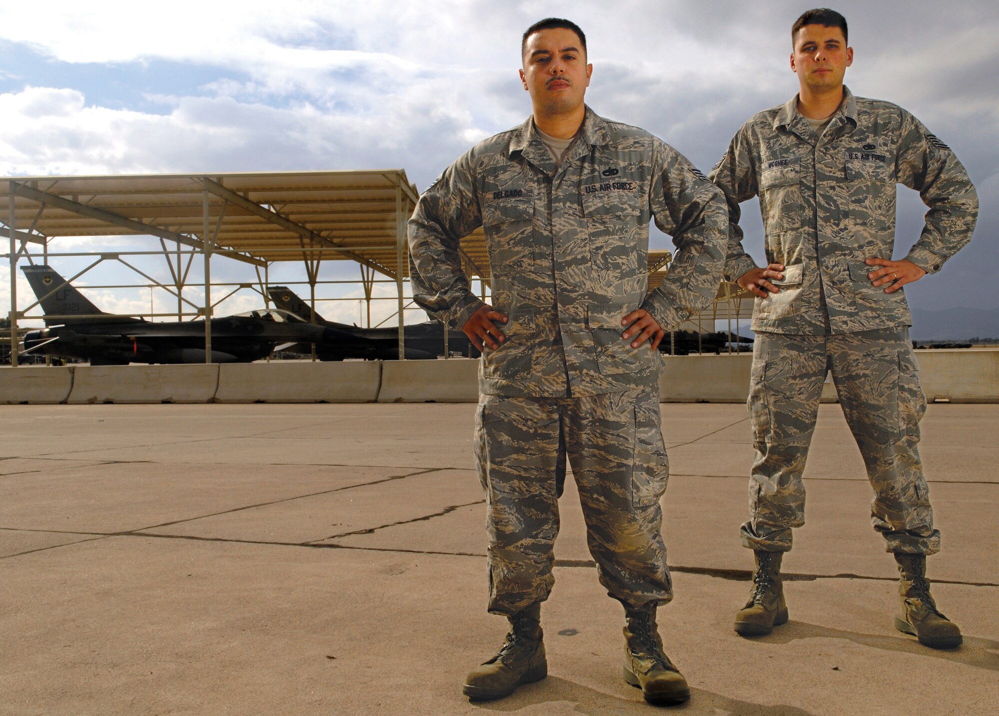 Staff Sgt. Lisandro Delgado (front) and Tech. Sgt. Christopher McGhee, 56th Maintenance Operations Squadron maintenance instructors, cornered two men who jumped over the fence onto Luke Air Force Base property Nov. 12. The two fence-jumpers were suspected of robbing a gas station across the street from Luke, and were in the process of fleeing when they scaled the base's fence. After seeing the men jump the fence, Sgts. Delgado and McGhee chased them down, and called security forces who took the suspects into custody.  (U.S. Air Force photo by Staff Sgt. Ian Dean)
