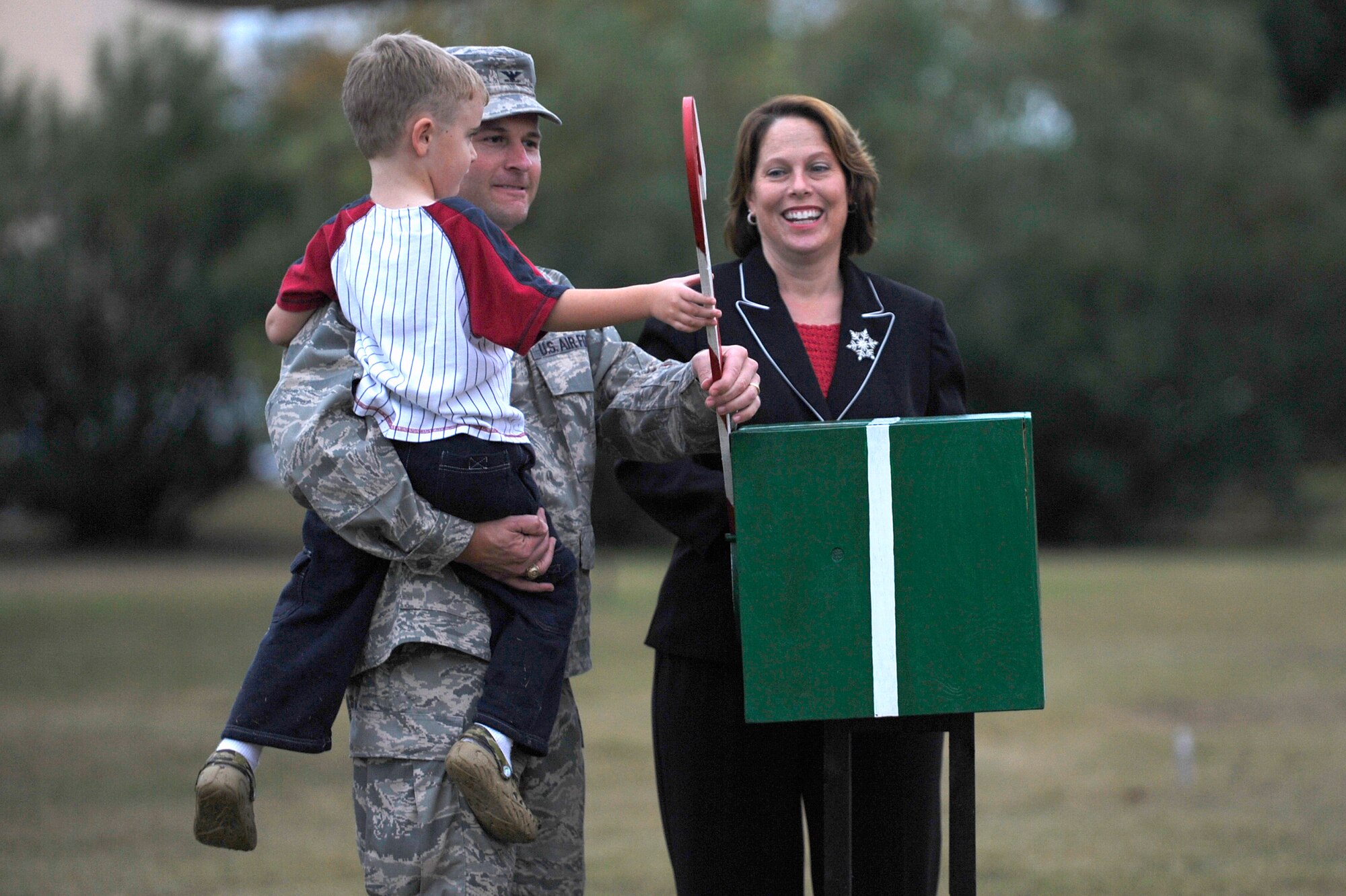Col. Greg Lengyel, 1st Special Operations Wing commander, Col. Lengyel’s wife Diane, and four year old Eric Young pull the switch to eliminate the base Christmas tree lights during the Tree Lighting Ceremony at the Hurlburt Airpark Dec. 4. The ceremony included a presentation of awards for the holiday greeting card contest, Christmas caroling, the lighting of the 30-foot tree, and a visit from Santa. (U.S. Air Force Photo/Senior Airman Julianne Showalter)