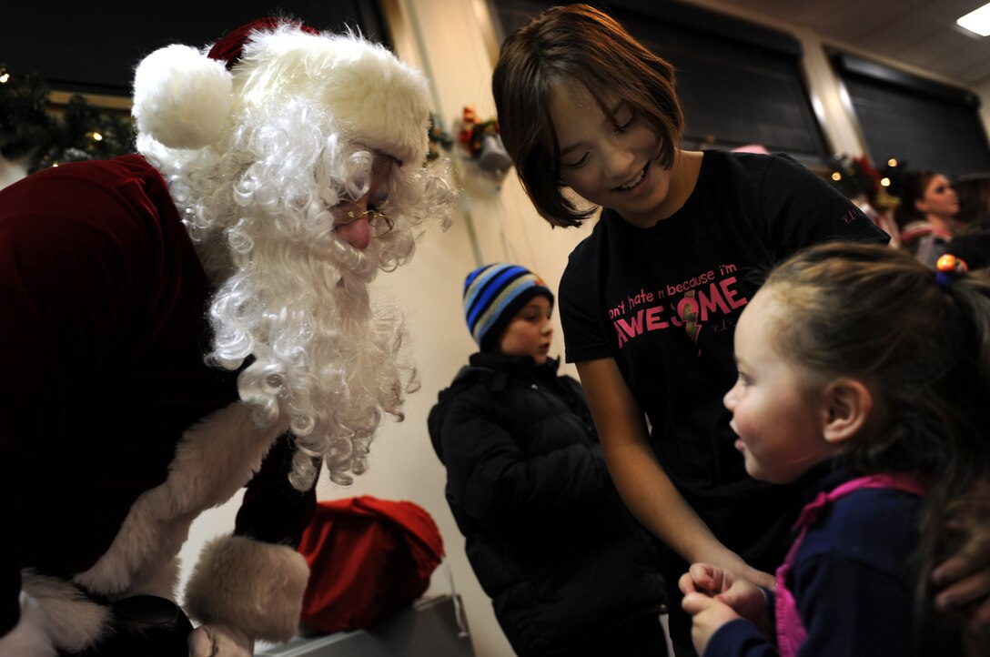 (Left to right) Santa Claus talks to military dependents, Maria Andrews and Lynnette Crespin during the annual holiday tree lighting ceremony at here, Dec. 4. After the tree was lit, Airmen and their families enjoyed snacks, carols, and time with Santa inside the Freedom Chapel Annex. (U.S. Air Force photo/Airman 1st Class Joshua J. Seybert)