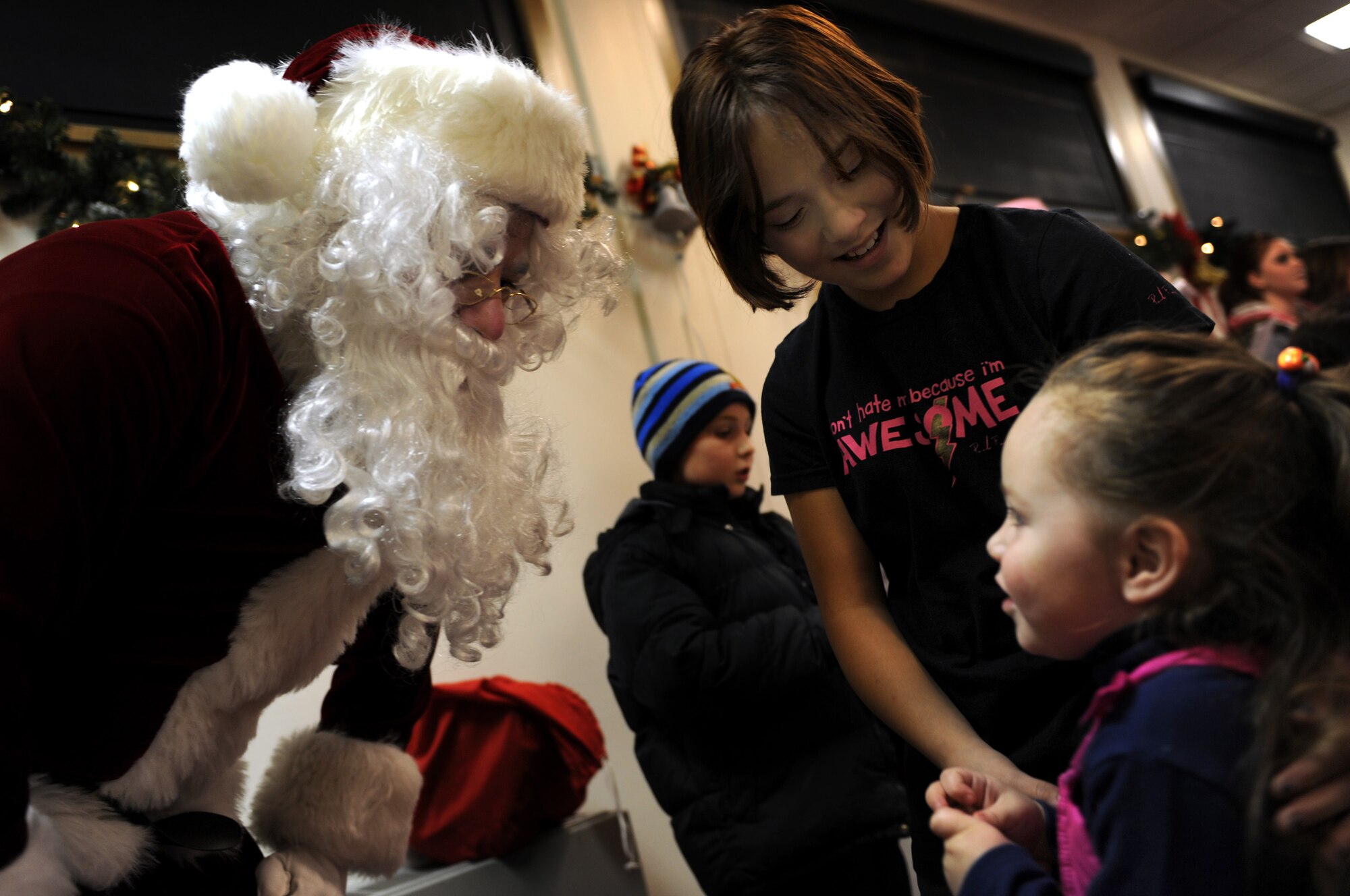 (Left to right) Santa Claus talks to military dependents, Maria Andrews and Lynnette Crespin during the annual holiday tree lighting ceremony at here, Dec. 4. After the tree was lit, Airmen and their families enjoyed snacks, carols, and time with Santa inside the Freedom Chapel Annex. (U.S. Air Force photo/Airman 1st Class Joshua J. Seybert)