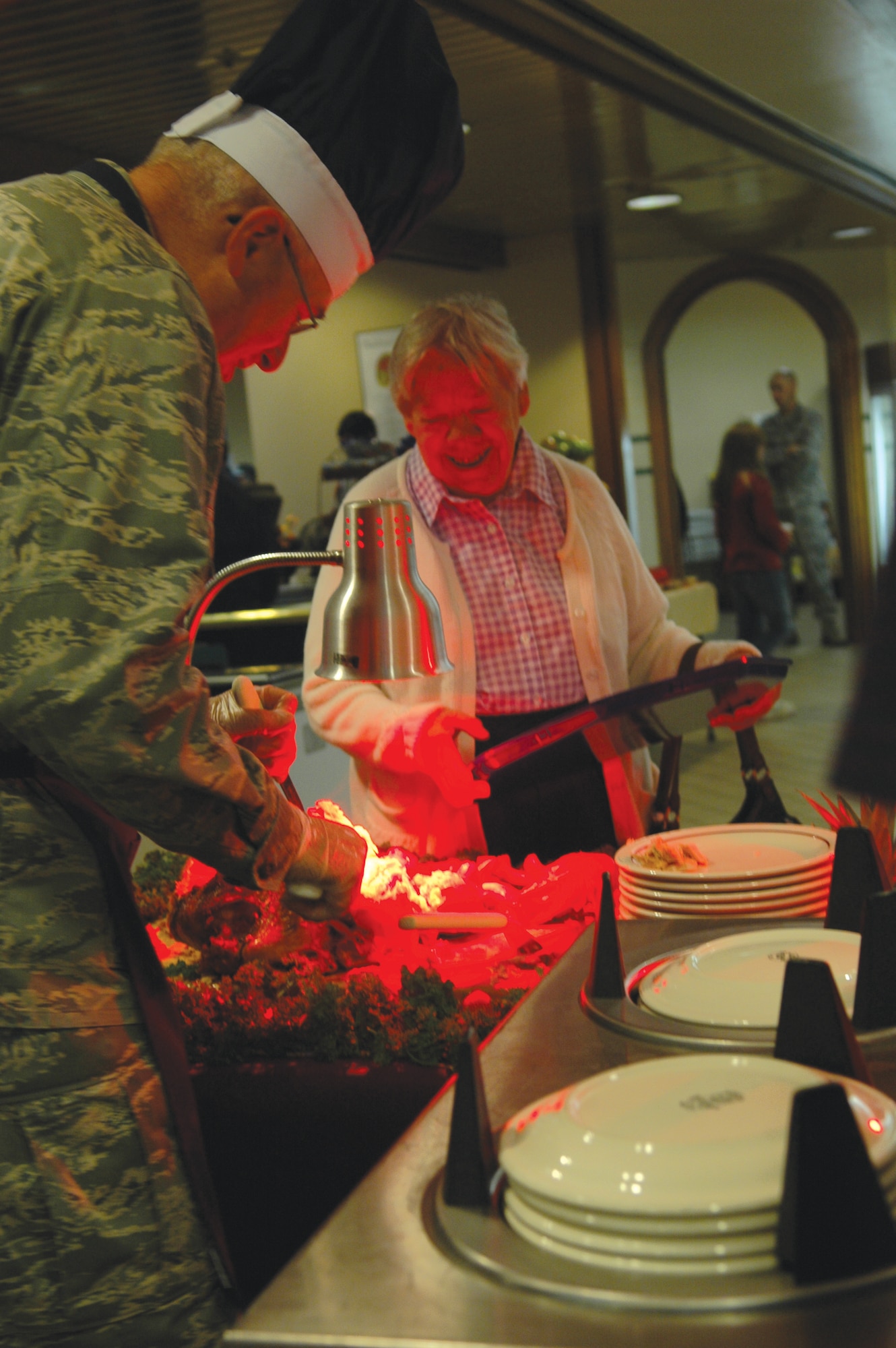 Maj. Gen. Loren Reno, Oklahoma City Air Logistics Center commander, carves a turkey for a retiree visiting the Vanway Dining Facility at Tinker on Thanksgiving. Commanders from across Tinker traditionally gather at the dining facitlity to serve troops and family members the holiday meal. The Force Support Squadron expected to serve 1,000 people.  