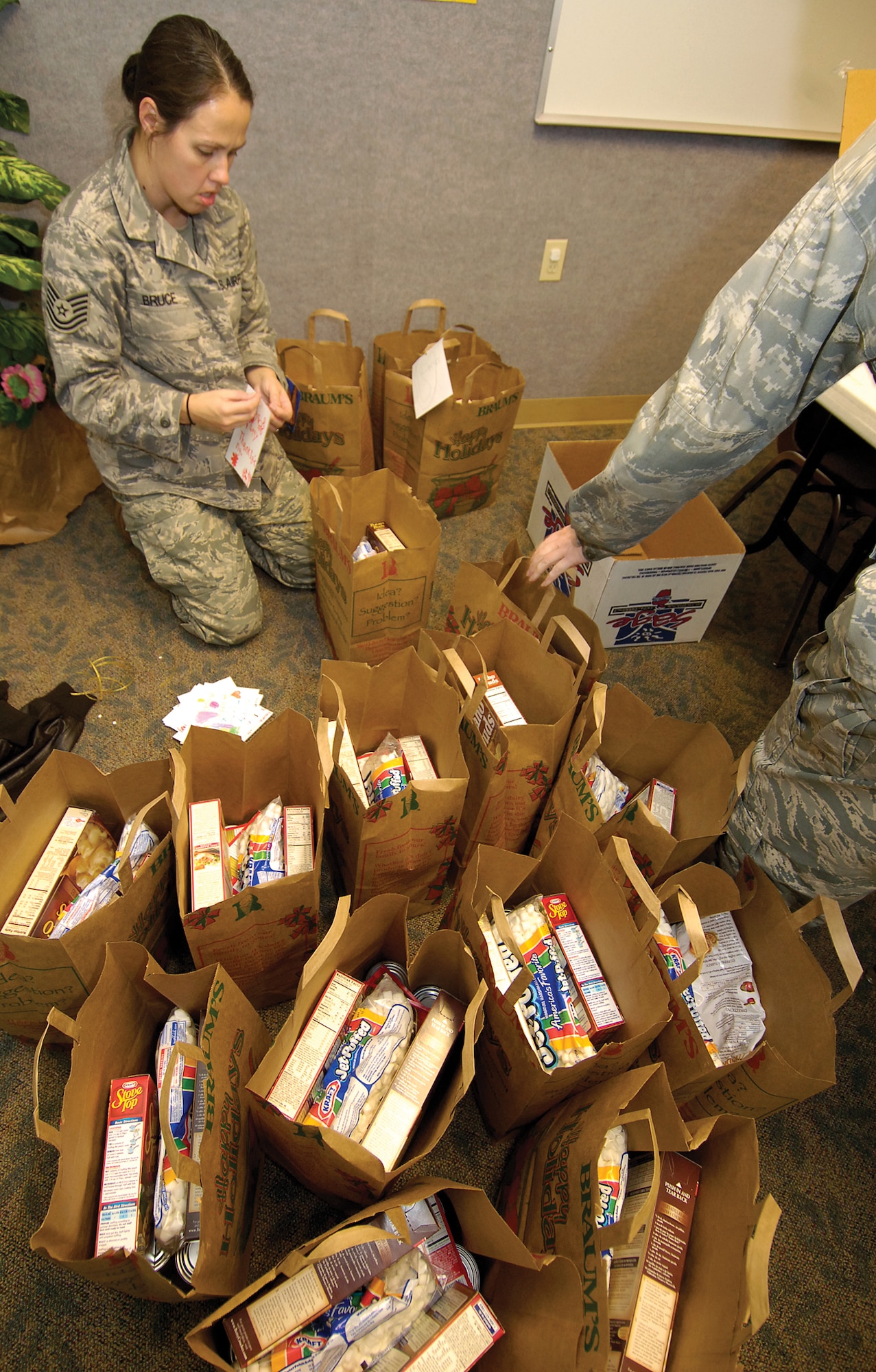 A sea of bags surrounds Tech. Sgt. Hope Bruce, 3rd Combat Communications Support Squadron. Members of Tinker’s Network 56 coordinated the Thanksgiving food drive to help approximately 331 Airmen and Sailors during the holiday. (Air Force photo/Margo Wright)