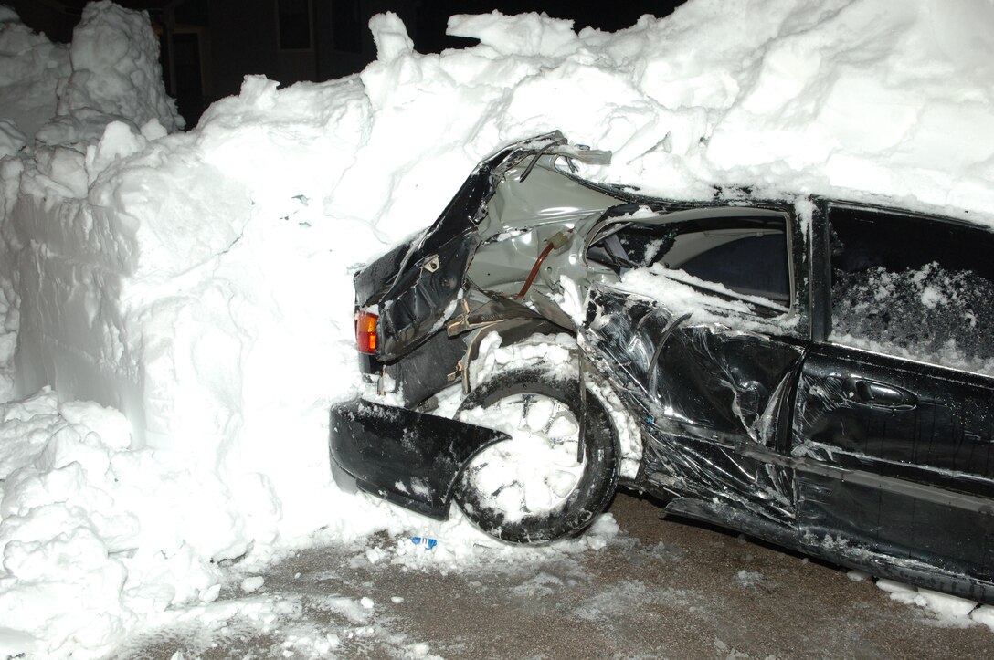 A vehicle sits covered in snow after being hit by a snow plow in base housing, Nov. 15, 2008. The vehicle was hit because it was not removed from the road before the snow fall. (U.S. Air Force photo/Senior Airman Kasey Zickmund)