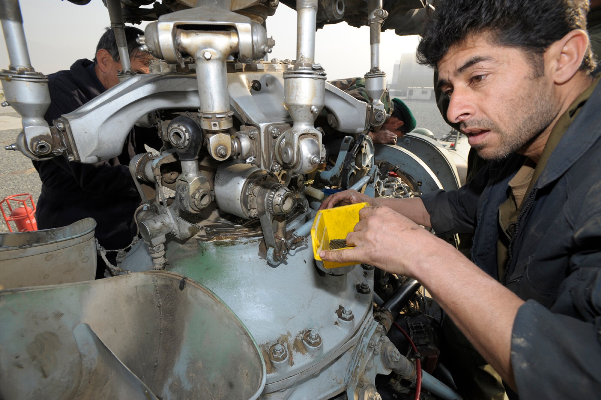 KABUL, Afghanistan -- An Afghan National Army Air Corps maintainer does periodic maintenance to the rotor head of a Mi-17 helicopter. The ANAAC is mentored by the 438th Air Expeditionary Wing and has made great strides in its ability to handle the airlift mission of the Afghan National Army. (U.S. Air Force photo/Master Sgt. Keith Brown)