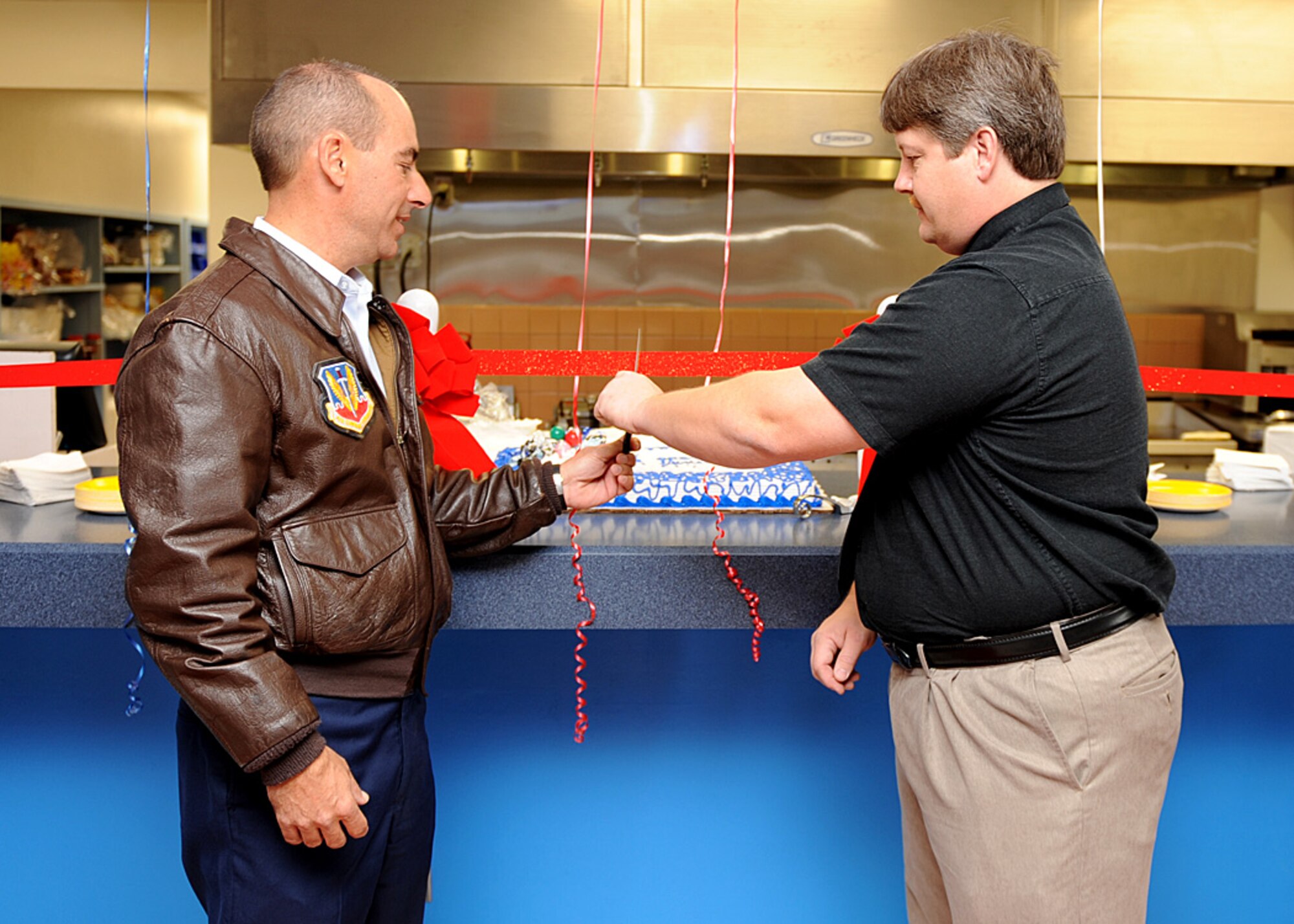 Col. Jeff Harrigian, 49th Fighter Wing commander, cuts the ribbon to officially reopen the Desert Lanes bowling alley snack bar Nov. 23 at Holloman Air Force Base, N.M.  The Desert Lane's snack bar reopened with the new items on the menu as well as the old ones.  (U.S. Air Force photo by Airman 1st Class John D. Strong II)
