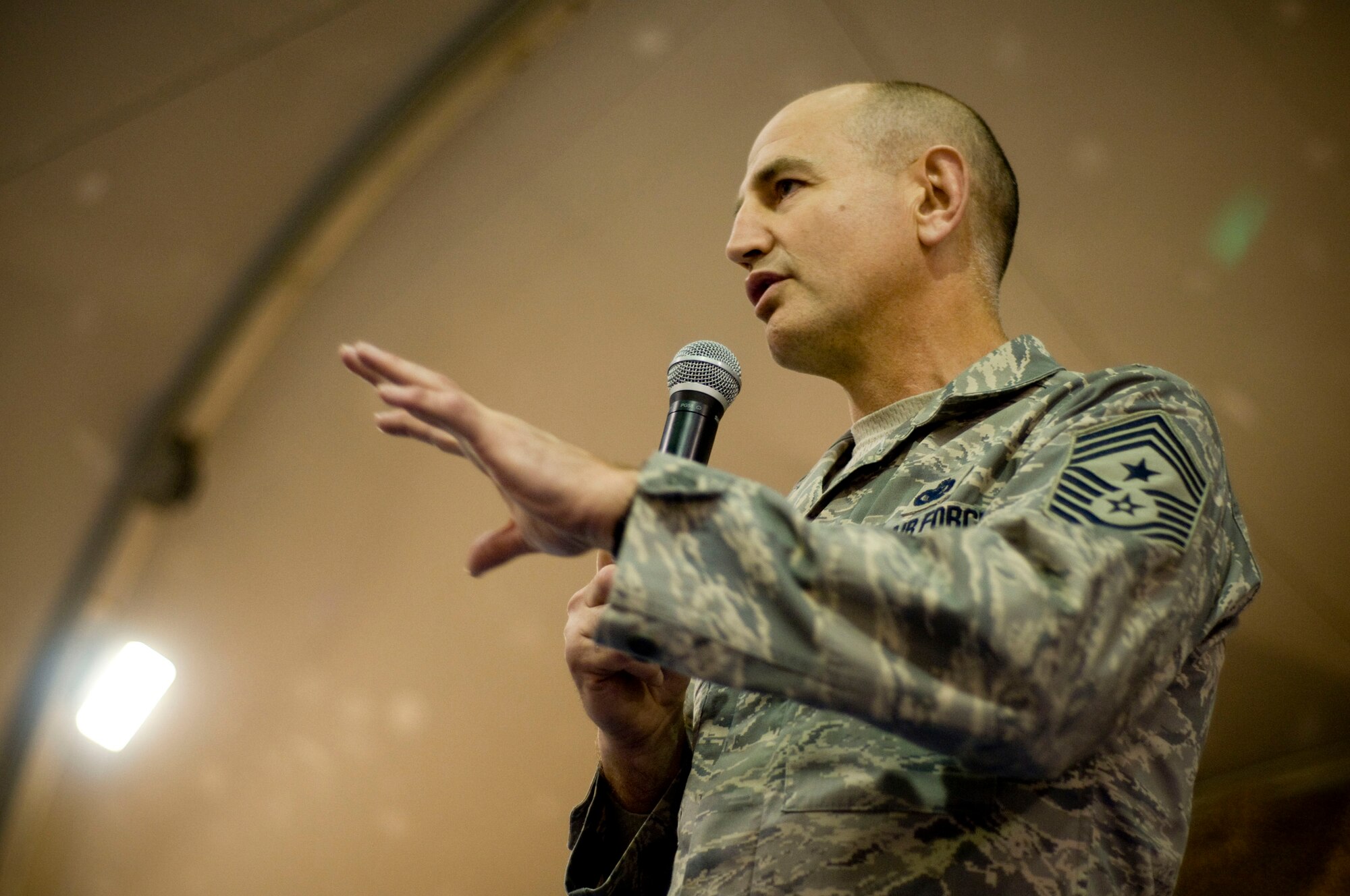 Command Chief Master Stephen Sullens, Air Combat Command, addresses a question during the Airman's Call at Bagram Air Field, Afghanistan, Dec. 4. Chief Sullens discussed the pros and cons of "on the spot physical training testing," in regards to the importance of a "fit to fight" Air Force. (U.S. Air Force photo by Staff Sgt. Samuel Morse)(Released)