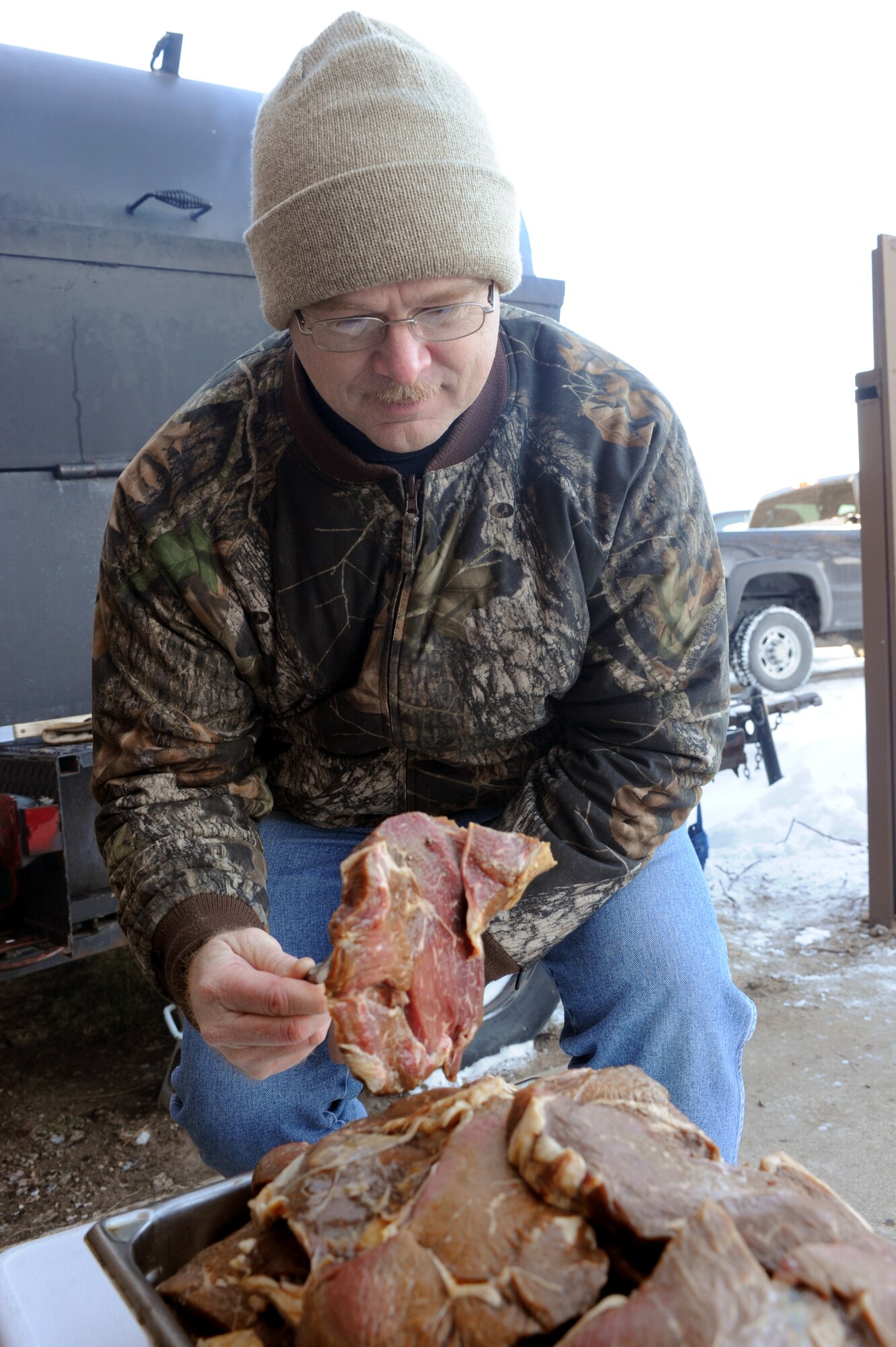 Chief Master Sergeant Stephen Cron, 28th Communications Squadron superintendent, examines a piece of steak during the Chief Steak Burn Luncheon here, Dec. 3.  The steak, which took 12 hours to marinate, is one of 450 steaks prepared for the event, which raised approximately $1,500. (U.S. Air Force photo/Airman 1st Class Adam Grant)
