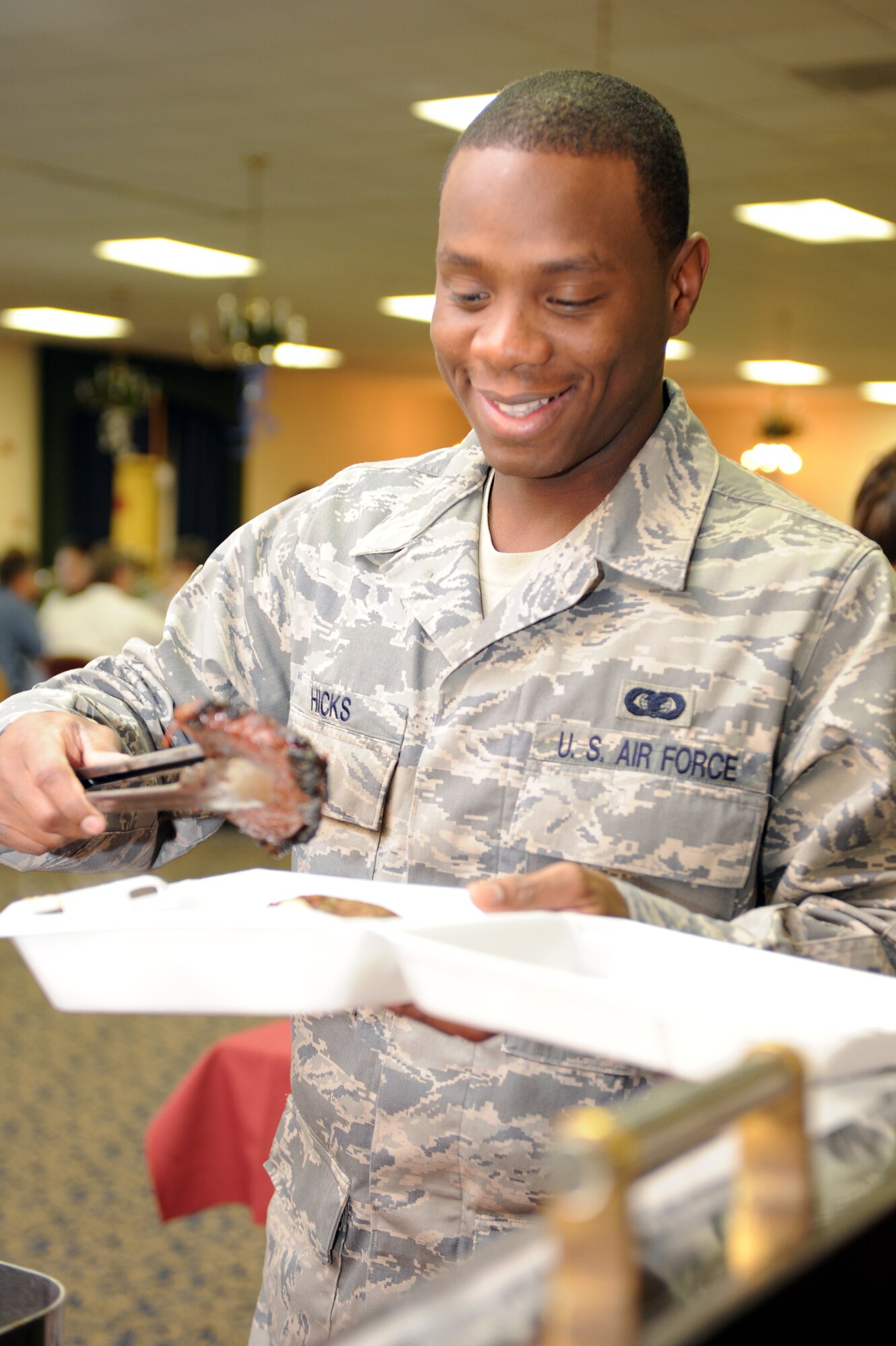 Airman 1st Class DCoridrion Hicks, 28th Operations Support Squadron enterprise information manager, selects a piece of steak during the Chief Steak Burn Luncheon here, Dec. 3. The event sold more than 400 tickets, and all profits gained from the event will support enlisted programs throughout the base. (U.S. Air Force photo/Airman 1st Class Adam Grant)
