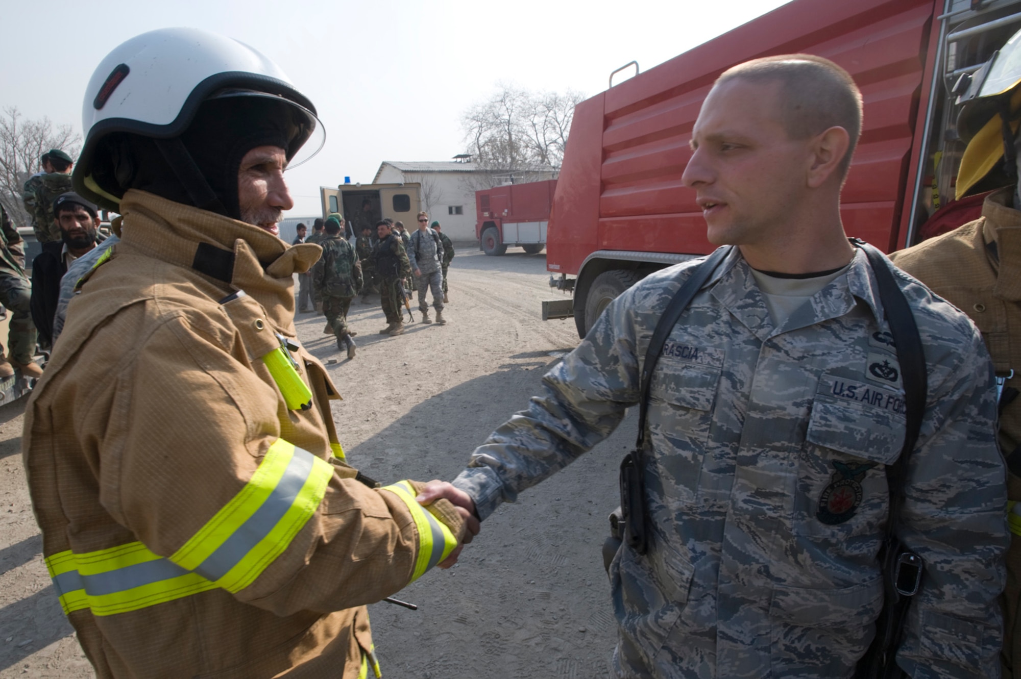 KABUL, Afghanistan -- Afghan National Army Air Corps Joint Fire Academy commandant, Master Sgt. Mike Marascia, shakes hand with ANAAC fire chief, Maj. Razuddin after a successful exercise. The ANAAC firefighters extinguished a fire in a abandoned building. Sergeant Marascia a fire protection mentor is deployed here from Langley Air Force Base, Va. (U.S. Air Force photo/Master Sgt. Keith Brown)