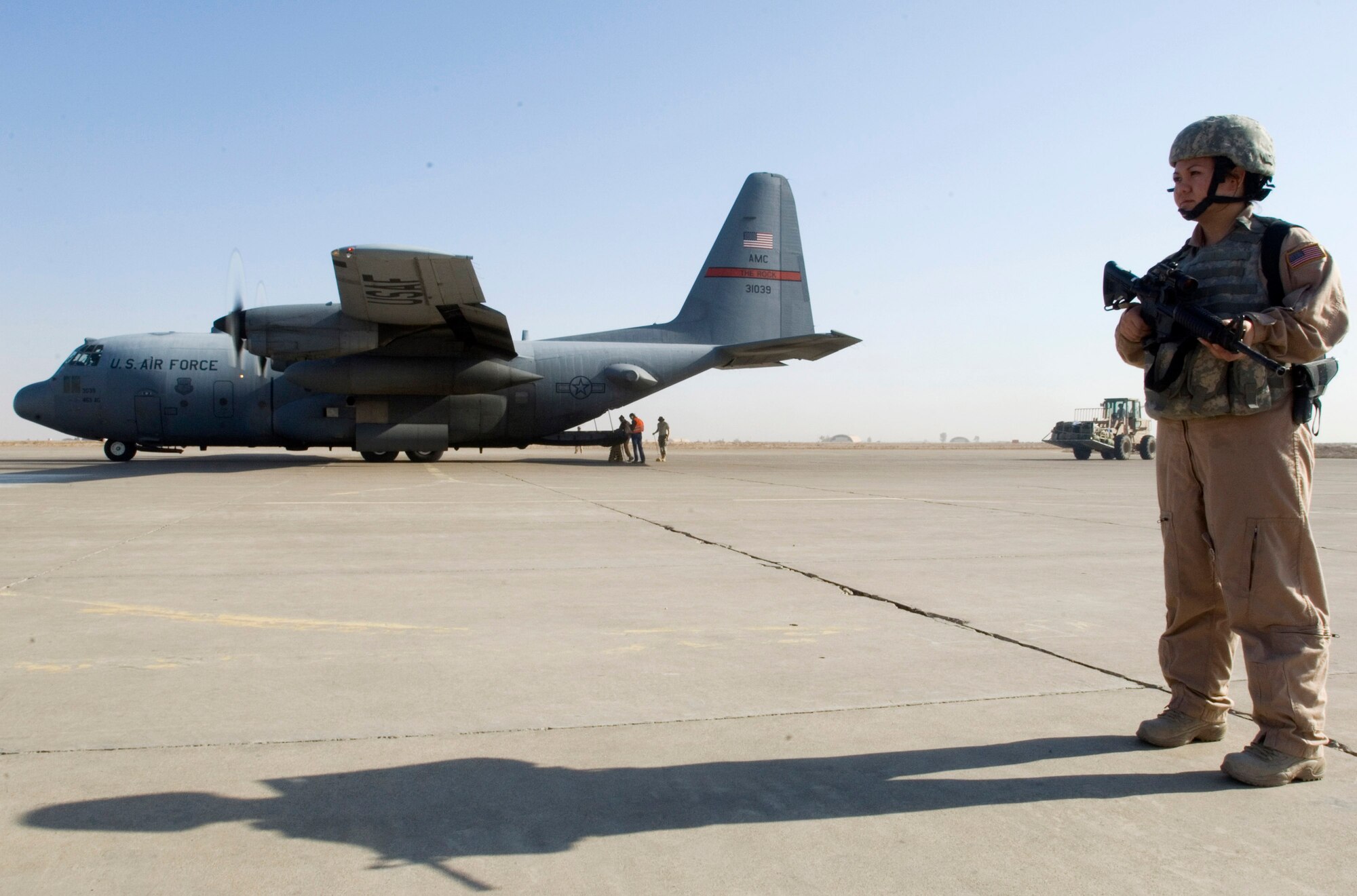 Senior Airman Rosie Munoz scans the area for threats while a 777th Expeditionary Airlift Squadron C-130 Hercules unloads cargo Nov. 22 at a remote location in Iraq. Airman Munoz is a member of a 332nd Expeditionary Security Forces Squadron Fly Away Security Team. She grew up in Seoul, South Korea, and calls El Paso, Texas, home. (U.S. Air Force photo/Tech. Sgt. Erik Gudmundson) 

