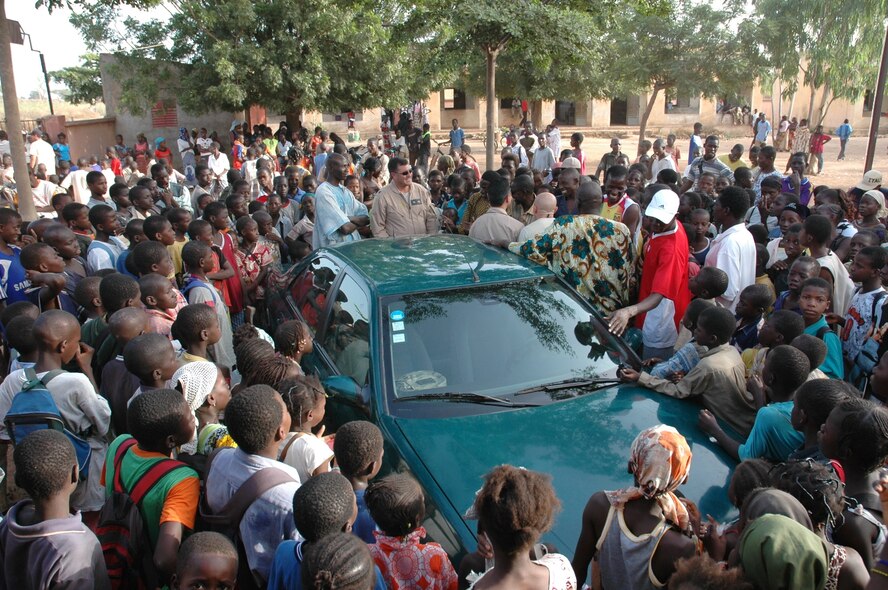 Lt. Col. Eric Hill, 8th Special Operations Squadron commander, Tech. Sgt. John Jones, Jr., 352nd Special Operations Group, and Capt. Rob Marshall, 8th SOS are enveloped by school children recently in Mali, Africa while making a donation of school supplies and sporting equipment. The Airmen, part of the Joint Special Operations Air Detachment, were in Mali supporting FLINTLOCK, a joint/combined training exercise conducted regularly in the Trans-Saharan region designed to build capacity and foster interoperability among African nations. The JSOAD donated $3,500 worth of supplies to the local school complex, and hosted a soccer game against a group of school children. (U.S. Air Force photo/1st Lt. Lauren Johnson)