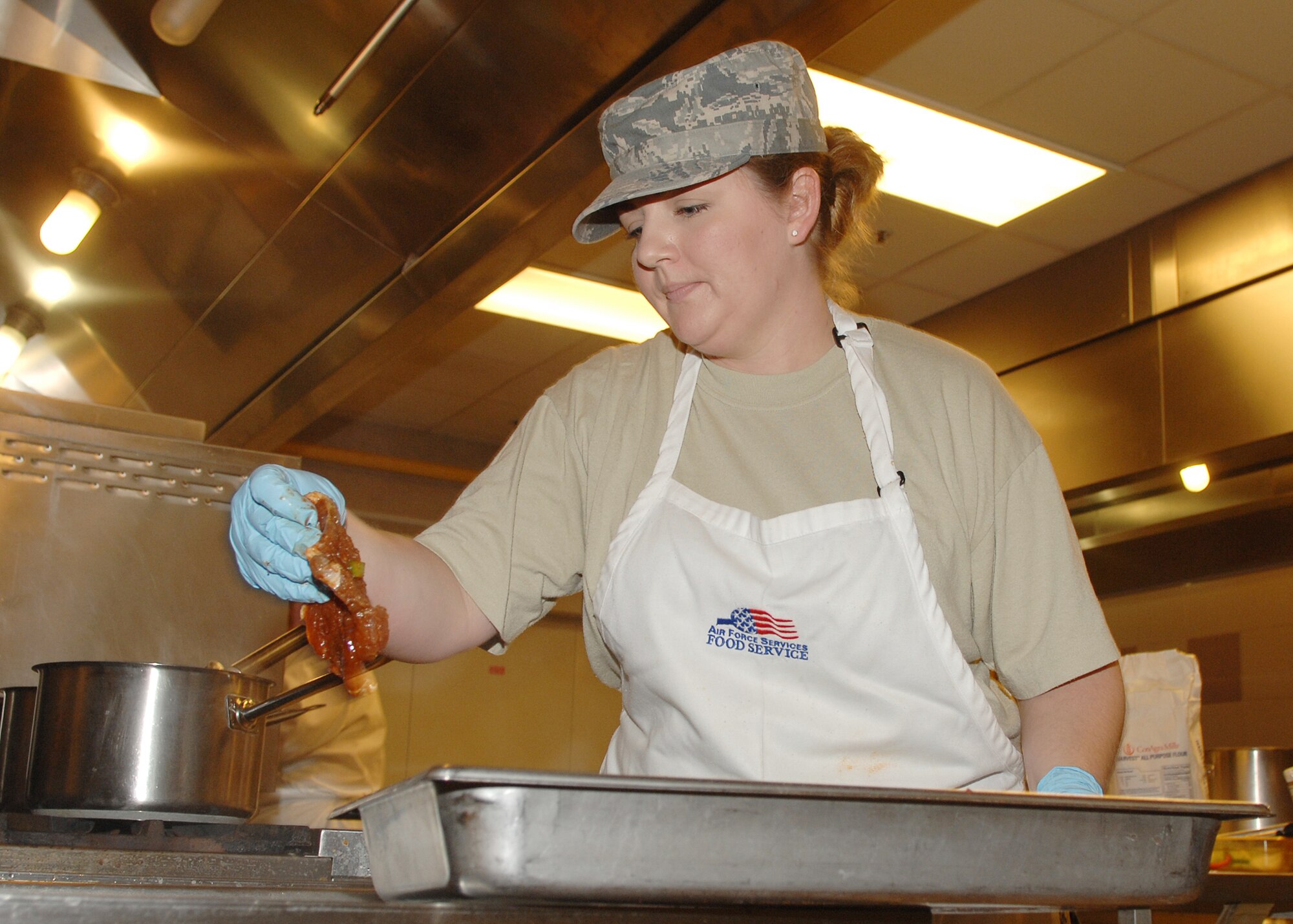 AVIANO AIR BASE, Italy --Senior Airman Tonya Walker, 31st Force Support Squadron, prepares and competes in the first Aviano Top Chef Competition Dec. 5. Both competitors were each slotted two hours to prepare their ingredients and whip up a southwestern style dish consisting of Mexican baked pork chops, Spanish style beans and macaroni and cheese. (U.S. Air Force photo/Senior Airman Taylor Marr)