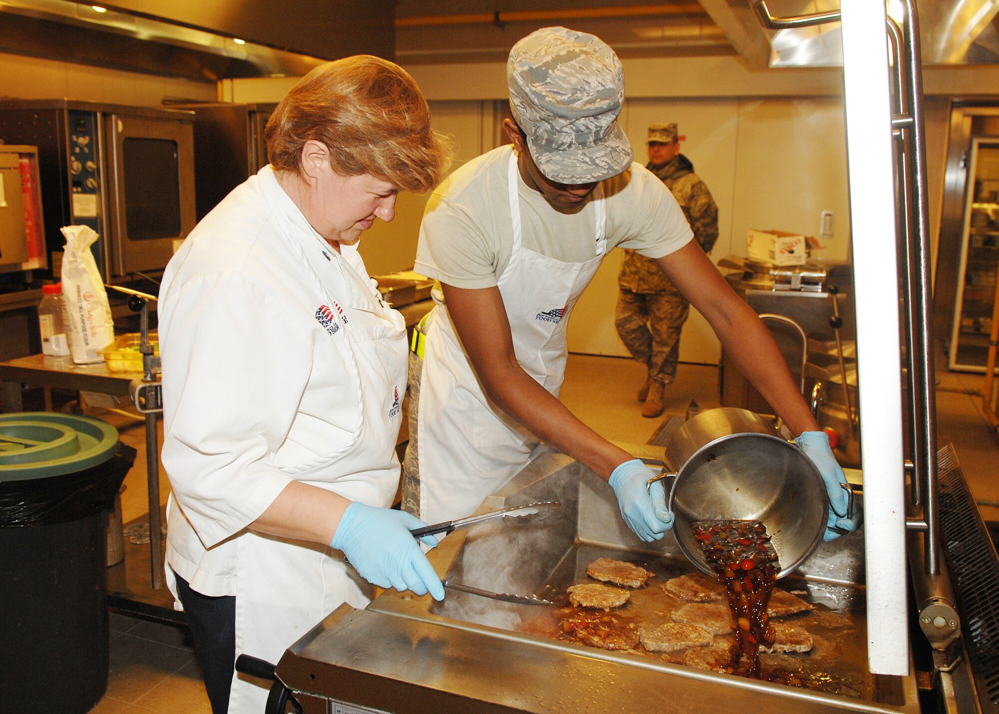 AVIANO AIR BASE, Italy --Airman First Class Shawn Haynes, 31st Force Support Squadron, pours ingredients onto pork chops during the Aviano Top Chef competition Dec. 5.  (U.S. Air Force photo/Senior Airman Taylor Marr)