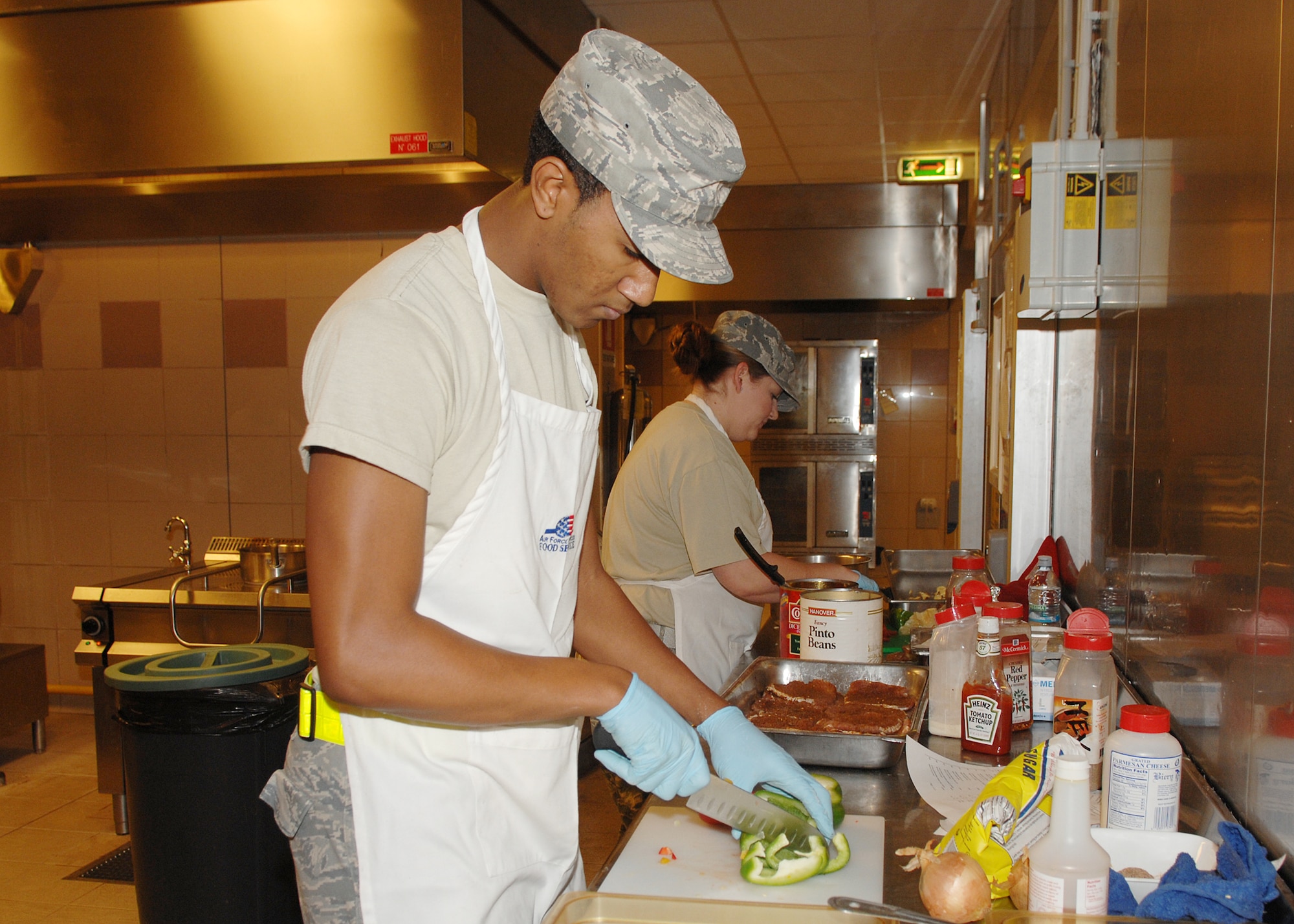 AVIANO AIR BASE, Italy --Airman First Class Shawn Haynes, 31st Force Support Squadron,  slices green peppers during the Aviano Top Chef competition Dec. 5. Senior Airman Tonya Walker and Airman 1st Class Shaun Haynes were each slotted two hours to prepare their ingredients and whip up a southwestern style dish consisting of Mexican baked pork chops, Spanish style beans and macaroni and cheese.  (U.S. Air Force photo/Senior Airman Taylor Marr)