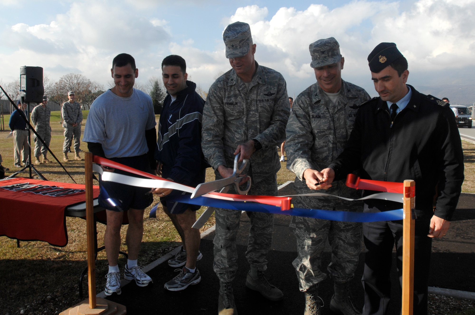Brig. Gen. Craig Franklin, 31st Fighter Wing commander, (middle) and other base leaders cut a ribbon to officially opening a portion of the perimeter running track Dec.3.  The new running track was constructed to provide Airmen a safe place to run around the flight line. (U.S. Air Force photo/Airman 1st Class Ashley Wood)

