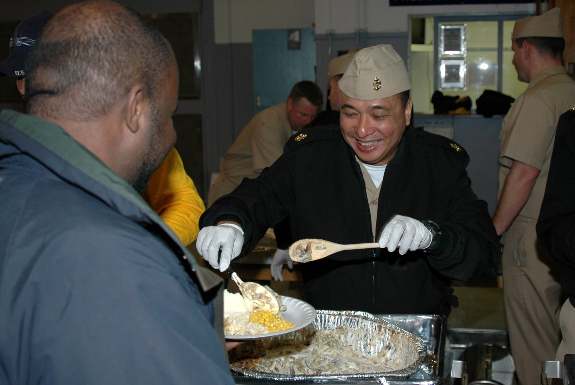 MISAWA AIR BASE, Japan -- Chief Petty Officer Sam Garana, Naval Air Facility Misawa, gives a healthy serving of dressing to civilian contractor Antonio Ruffin, Naval Air Facility Misawa, during the annual pre-Thanksgiving luncheon held onboard NAF Misawa Nov. 21, 2008. The meal is sponsored each year by the chiefs and officers from the command, as a way of showing appreciation to the Sailors and civilians who work there. This year, more than 600 people were fed more than 1,000 pounds of food, including turkey, ham, dressing, several kinds of vegetables, and a variety of pies. (U.S. Navy photo by Chief Petty Officer Brian Naranjo)