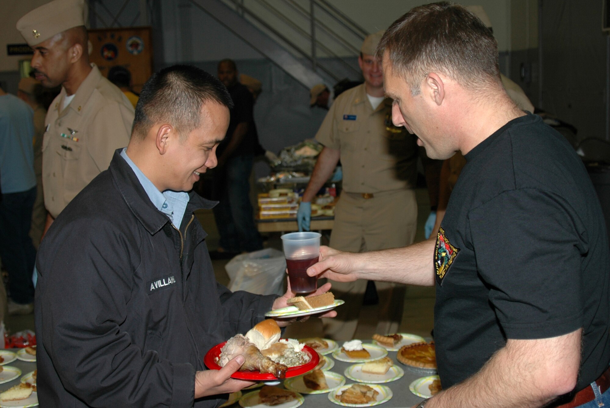 MISAWA AIR BASE, Japan -- Chief Petty Officer Troy Snyder, Naval Air Facility Misawa, carefully gives a cup of tea to Petty Officer 1st Class Nelson Avillanoza, Naval Air Facility Misawa, during the annual pre-Thanksgiving luncheon held onboard the facility Nov. 21, 2008. The meal is sponsored each year by the chiefs and officers from the command, as a way of showing appreciation to the Sailors and civilians who work there. This year, more than 600 people were fed more than 1,000 pounds of food, including turkey, ham, dressing, several kinds of vegetables, and a variety of pies. (U.S. Navy photo by Chief Petty Officer Brian Naranjo)