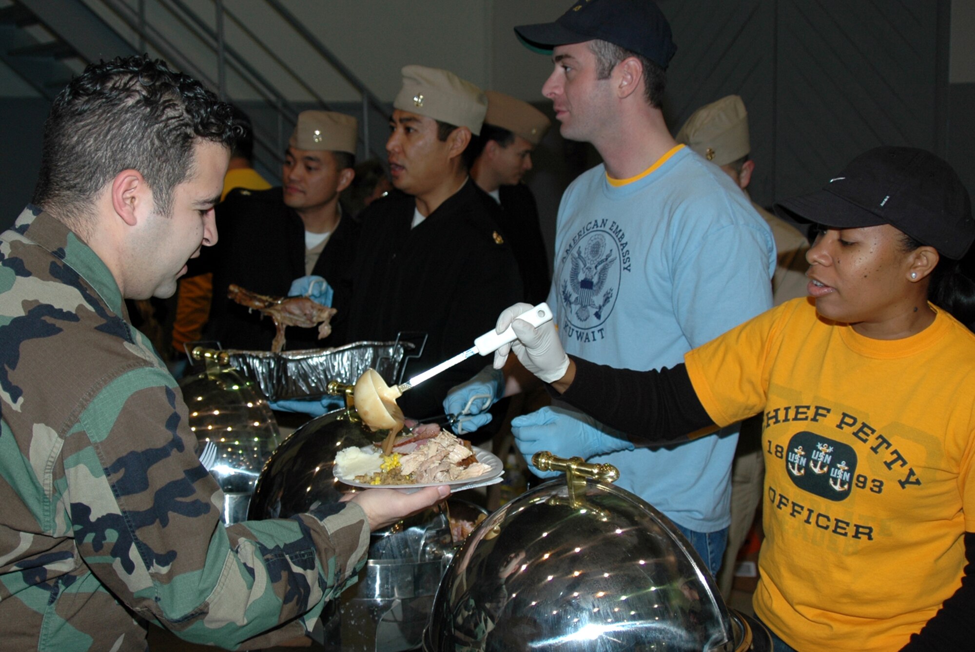 MISAWA AIR BASE, Japan -- Chief Petty Officer Nadine Fridy, Naval Air Facility Misawa, serves gravy to Petty Officer 2nd Class Angel Vicente, Naval Air Facility Misawa, during the annual pre-Thanksgiving luncheon held onboard the facility Nov. 21, 2008. This year, more than 600 people were fed more than 1,000 pounds of food, including turkey, ham, dressing, several kinds of vegetables, and a variety of pies. (U.S. Navy photo by Chief Petty Officer Brian Naranjo)