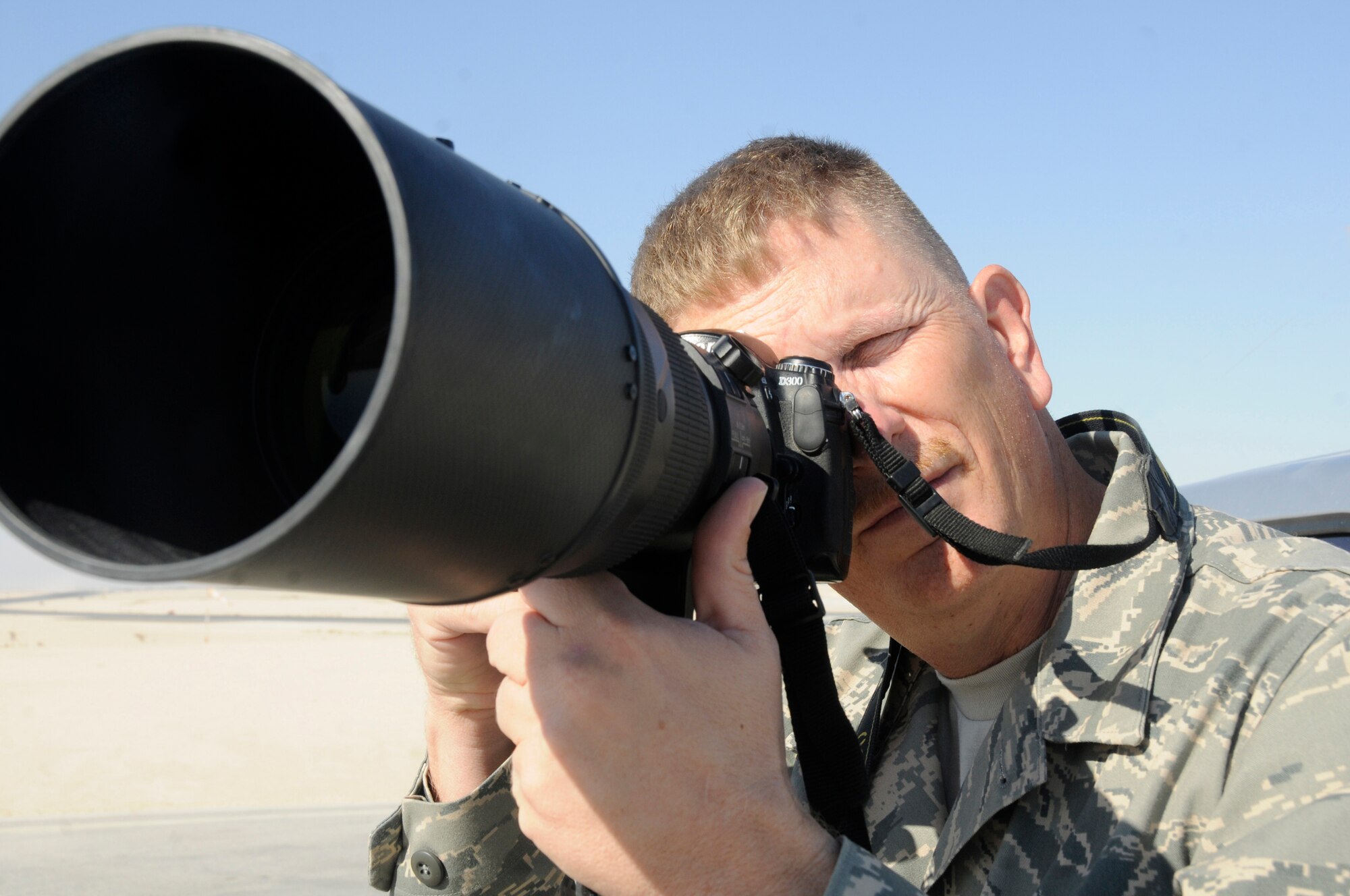 Tech. Sgt. Michael Boquette, a photographer assigned to the 379th Air Expeditionary Wing, snaps a photo on the flight line Dec. 4, at an undisclosed air base in Southwest Asia.  Public Affairs photographers, broadcasters and journalists document Airmen's GWOT efforts and use their products to inform the American people.  Sergeant Boquette, a native of St. Charles, Mich., is deployed from Andersen Air Force Base, Guam, in support of Operations Iraqi and Enduring Freedom and Joint Task Force-Horn of Africa. (U.S. Air Force photo by Staff Sgt. Darnell T. Cannady/Released)
