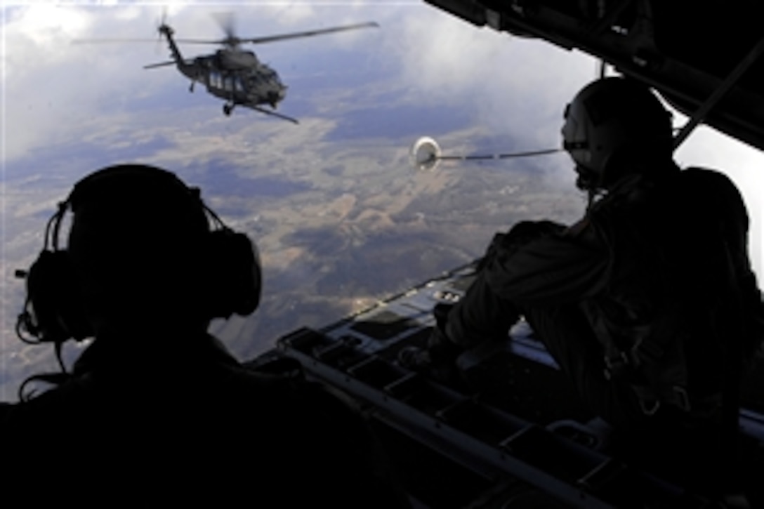 U.S. Air Force Senior Airman Christopher Elder and Staff Sgt. Jeremy Mayo watch as a U.S. Army MH-60K Blackhawk helicopter assigned to the 101st Airborne Division maneuvers to connect the aircraft's refueling probe to the C-130P boom to transfer fuel during an aerial refueling over Fort Campbell, Ky., Dec. 2, 2008. Edler and Mayo, both loadmasters are assigned to the 9th Special Operations Squadron.
