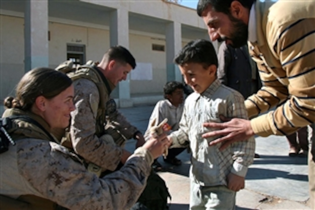 U.S. Navy Petty Officer 2nd Class Bridget Shanahan and Marine Corps Lance Cpl. Michael Johnson hand out stuffed animals to students at Houran Primary School in Rutbah, Iraq, Dec. 2, 2008. Shanahan is a corpsman assigned to 2nd Combat Logistics Battalion, Regimental Combat Team 2, and Johnson is a wireman assigned to Headquarters and Service Company, 2nd Battalion, 25th Marine Regiment, Regimental Combat Team 5.