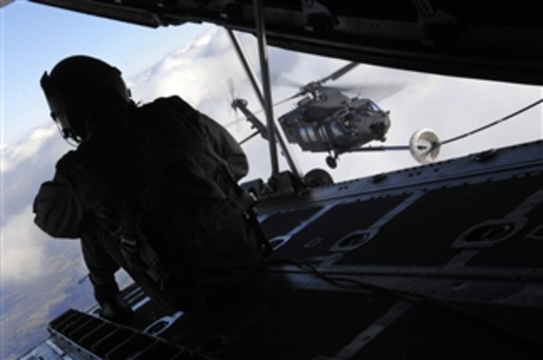 U.S. Air Force Staff Sgt. Jeremy Mayo, a loadmaster from the 9th Special Operations Squadron, looks for signs of difficulty during an aerial refueling mission with a U.S. Army MH-60K Blackhawk helicopter assigned to the 101st Airborne Division over Fort Campbell, Ky., on Dec. 2, 2008.  