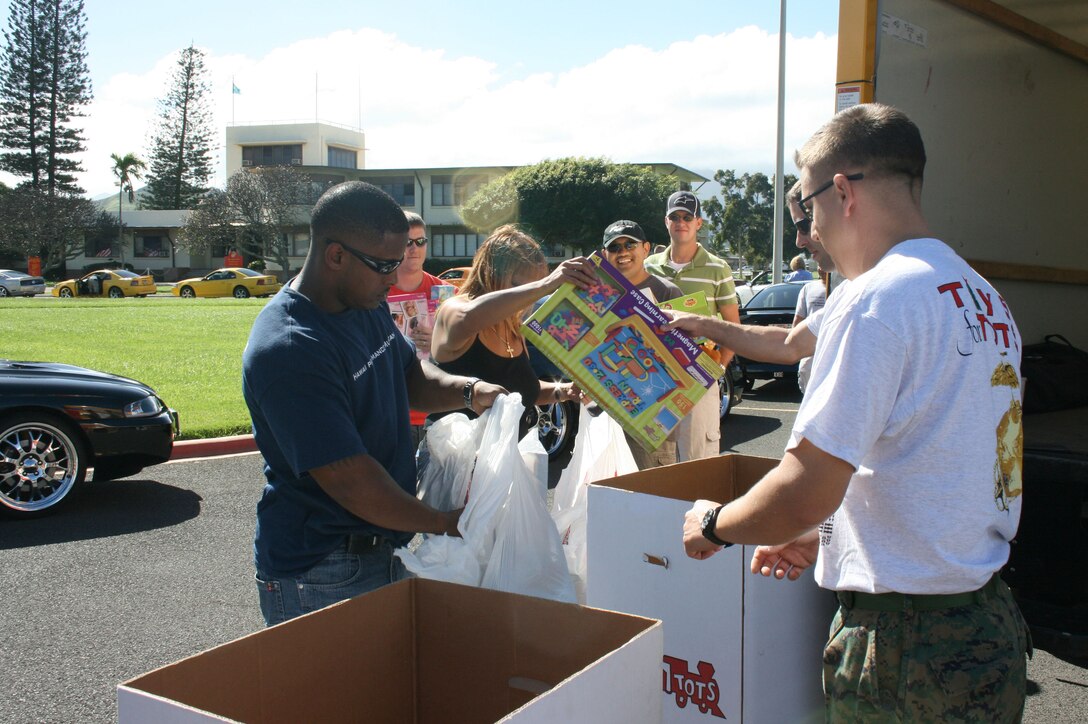 Members of the Hawaii Performance Mustangs club drop off toy donations with Gunnery Sgt. Chris Whitley and Staff Sgt. John Hassel of the 4th Force Reconnaissance Company at the rally point of the 34th Annual Oahu Car Club Toys Cruise from Kapolei to MCBH.