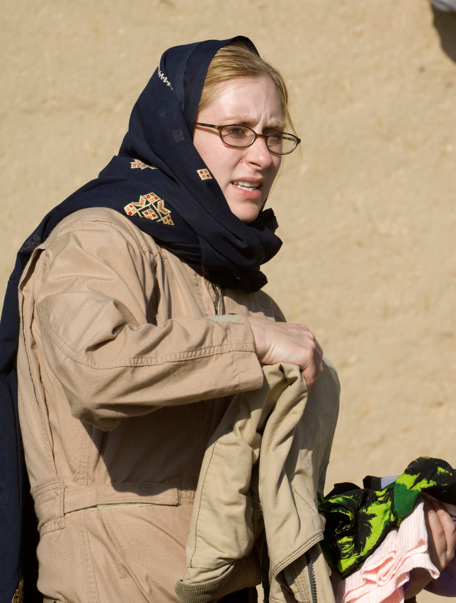PARWAN REFUGEE CAMP, Afghanistan -- Staff Sgt.Tammie Moore helps organize donated shoes at a humanitarian assistance visit here. The clothes, shoes, coats and blankets brought to the refugee camp were donations made by American citizens. The Kapisa and Pawarn Provincial Reconstruction Team worked with the Afghan Department of Refugees and Reparation to coordinate the humanitarian assistance drop. Sergeant Moore is deployed from Spangdahlem Air Base, Germany, as a journalist to the Air Force Central Command News Team. (U.S. Air Force photo/Master Sgt. Keith Brown)
