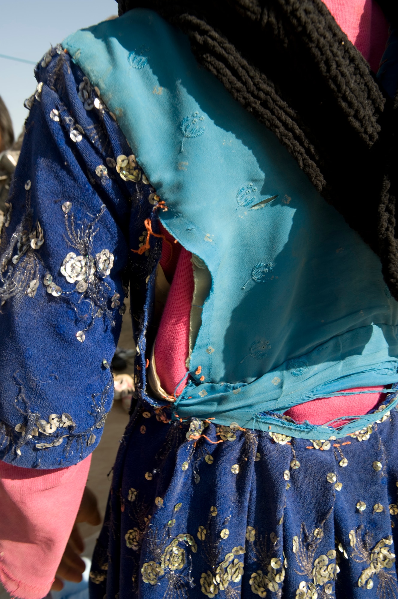 PARWAN REFUGEE CAMP, Afghanistan -- An Afghan girl's clothes shows the need for the clothes, coats and shoes donated during a humanitarian assistance visit here. The Kapisa and Pawarn Provincial Reconstruction Team worked with the Afghan Department of Refugees and Reparation to coordinate the humanitarian assistance drop. The Parwan Refugee Camp is home to some of the poorest people in Afghanistan.
(U.S. Air Force photo/Master Sgt. Keith Brown)
