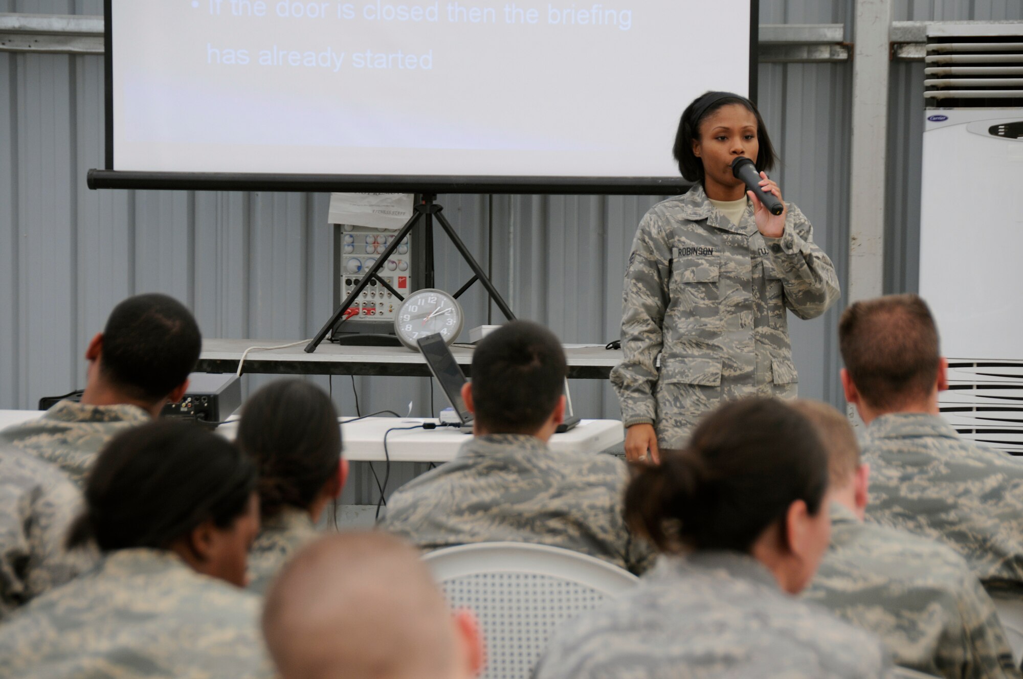 SOUTHWEST ASIA -- Senior Airman Stephanie Robinson from the 380th Expeditionary Force Support Squadron briefs personnel at their initial in-processing briefing here Nov. 21. PERSCO manages the transition every time with an initial briefing to ensure all paperwork is current and available, followed by a Warrior Brief with specific about the 380th. Airman Robinson is deployed from the 341st FSS, Malmstrom Air Force Base, Mont., her hometown is Eatonville, Wash. (U.S. Air Force photo/Tech. Sgt. Christopher A. Campbell)(released)