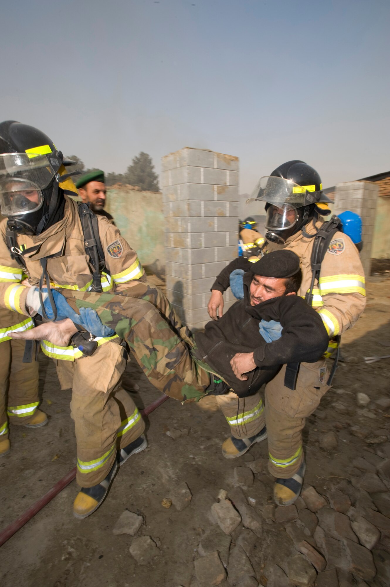 KABUL, Afghanistan --Members of the Afghan National Air Corps fire protection unit extract a simulated victim during a live fire response drill testing the teams response. The responding fire fighters are graduates of the Joint Fire Academy here, which was established and mentored by Master Sgt. Mike Marascia. Sergeant Marascia is a member of the 438th Air Expeditionary Wing at Kabul, which mentors the ANAAC  on a variety of air support operations. (U.S. Air Force photo/Master Sgt. Keith Brown)
