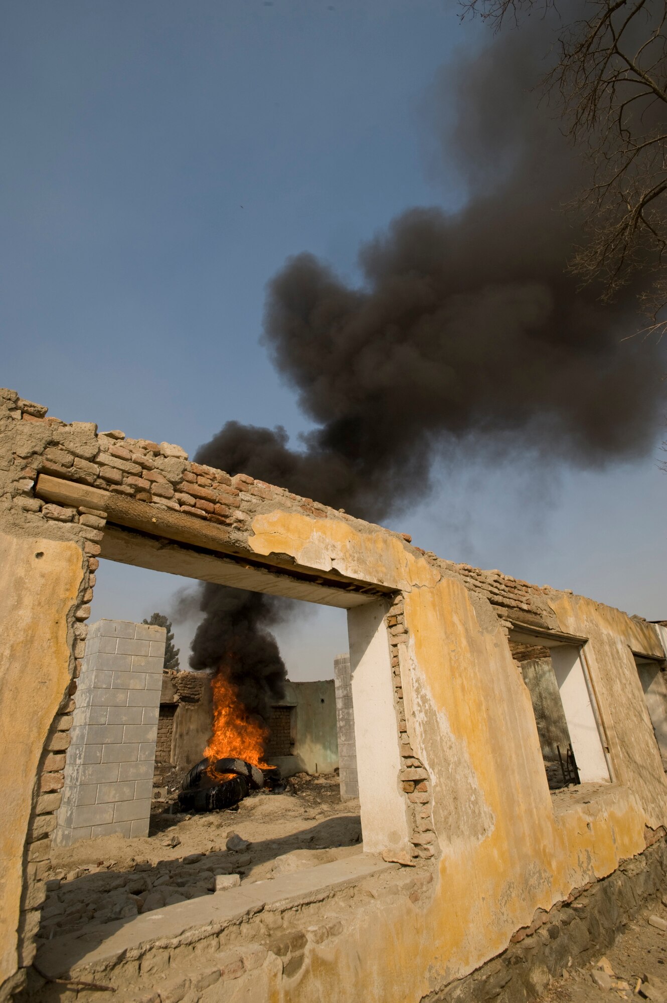 KABUL, Afghanistan -- As part of a training exercise a fire burns in a dilapidated building burn before the Afghan National Army Air Corp firefighters to respond to extinguish it. The responding fire fighters are graduates of the Joint Fire Academy here, which was established and mentored by Master Sgt. Mike Marascia. Sergeant Marascia is a member of the 438th Air Expeditionary Wing at Kabul, which mentors the ANAAC a variety of air support operations. (U.S. Air Force photo/Master Sgt. Keith Brown)