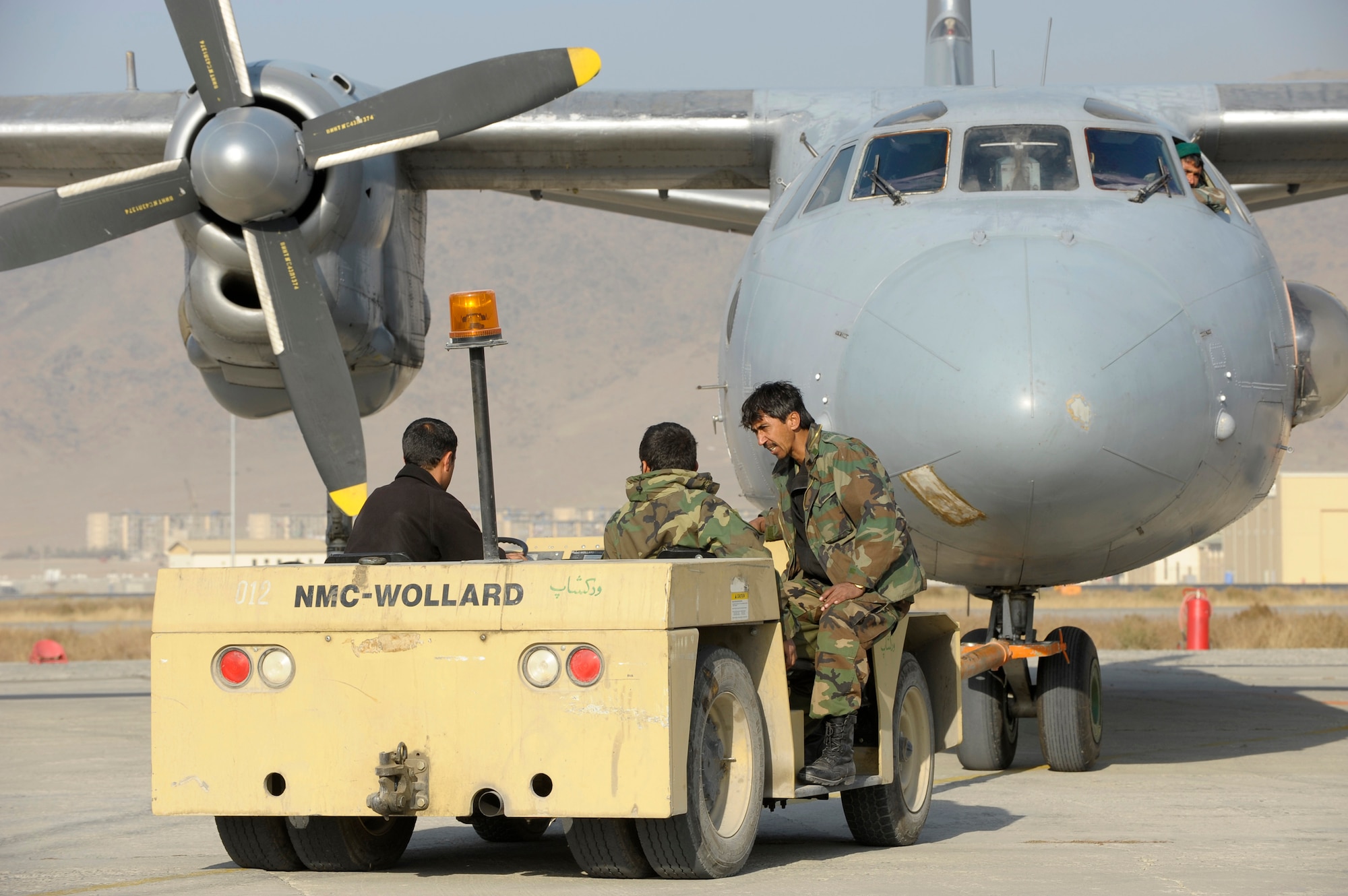 KABUL, Afghanistan -- An Afghan National Army Air Corps maintenance personnel push a An-32 into its parking place after a mission here. The ANAAC is being mentored by members of the 438th Air Expeditionary Wing on all aspects of flying operations. (U.S. Air Force photo/Master Sgt. Keith Brown)