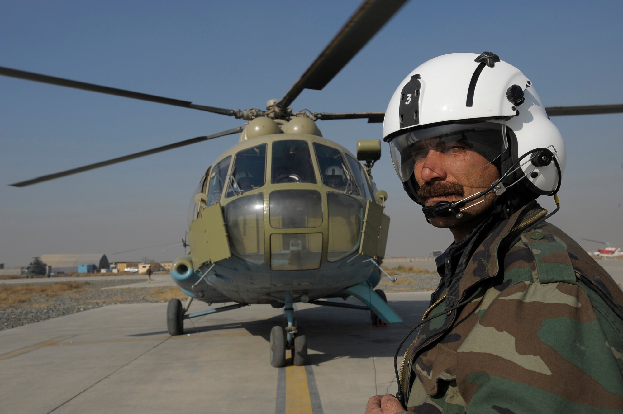 KABUL, Afghanistan -- An Afghan National Army Air Corps Mi-17 flight engineer stands by during engine start-up before a mission here. The ANAAC crews are mentored by the 438th Air Expeditionary Wing. U.S. Air Force pilots assigned to the wing regularly fly with the Afghan crews as instructor pilots on the Soviet built helicopter. (U.S. Air Force photo/Master Sgt. Keith Brown)