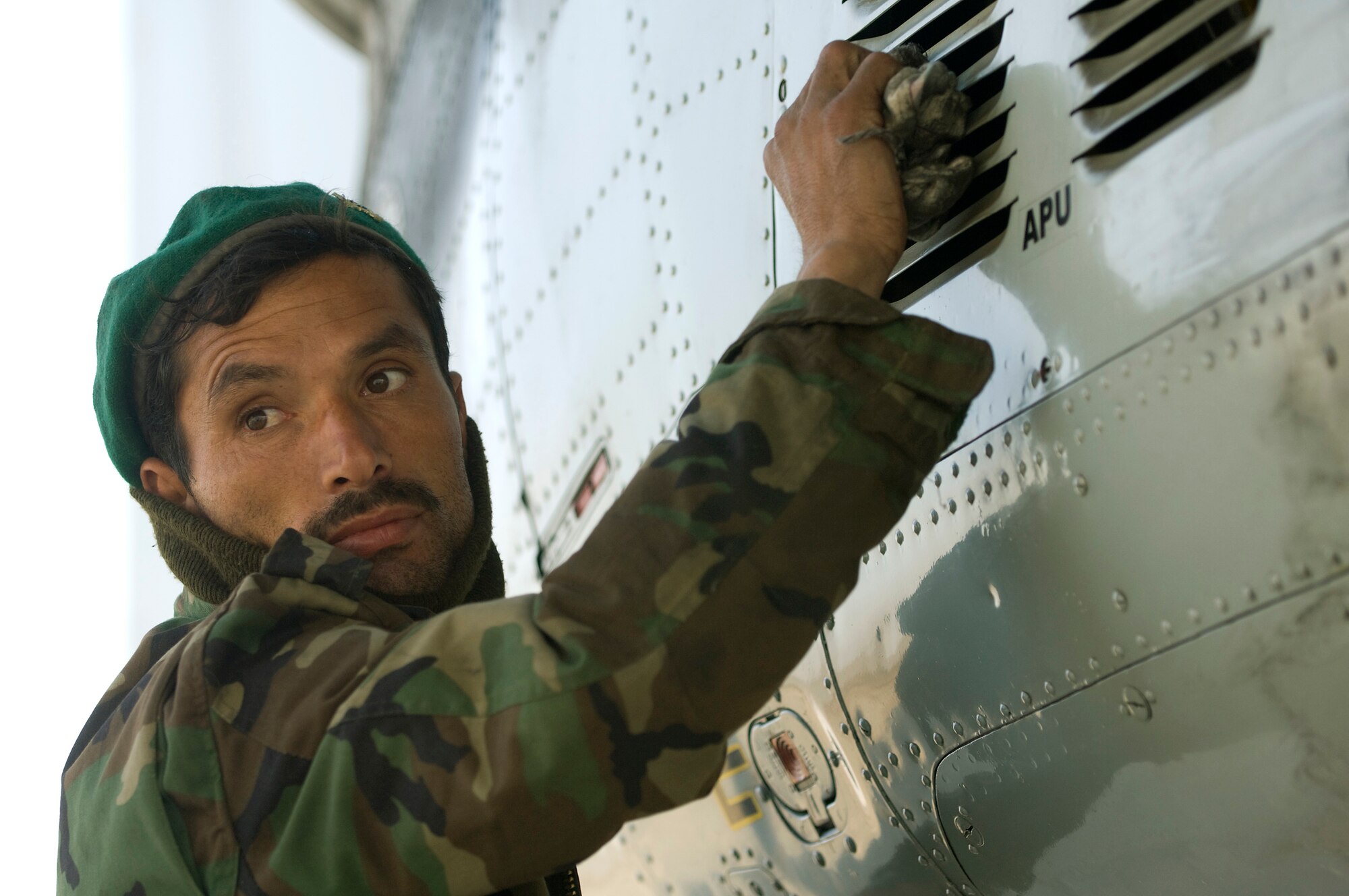 KABUL, Afghanistan -- Afghan National Army Air Corps An-26 crew chief cleans the aircraft after a mission here. The ANAAC is being mentored in western methodologies of flying operations by members of the 438th Air Expeditionary Wing. 
The force has made tremendous strides in the last year. The ANAAC went from flying 10 percent of Afghan support missions to 90 percent. (U.S. Air Force photo/Master Sgt. Keith Brown)