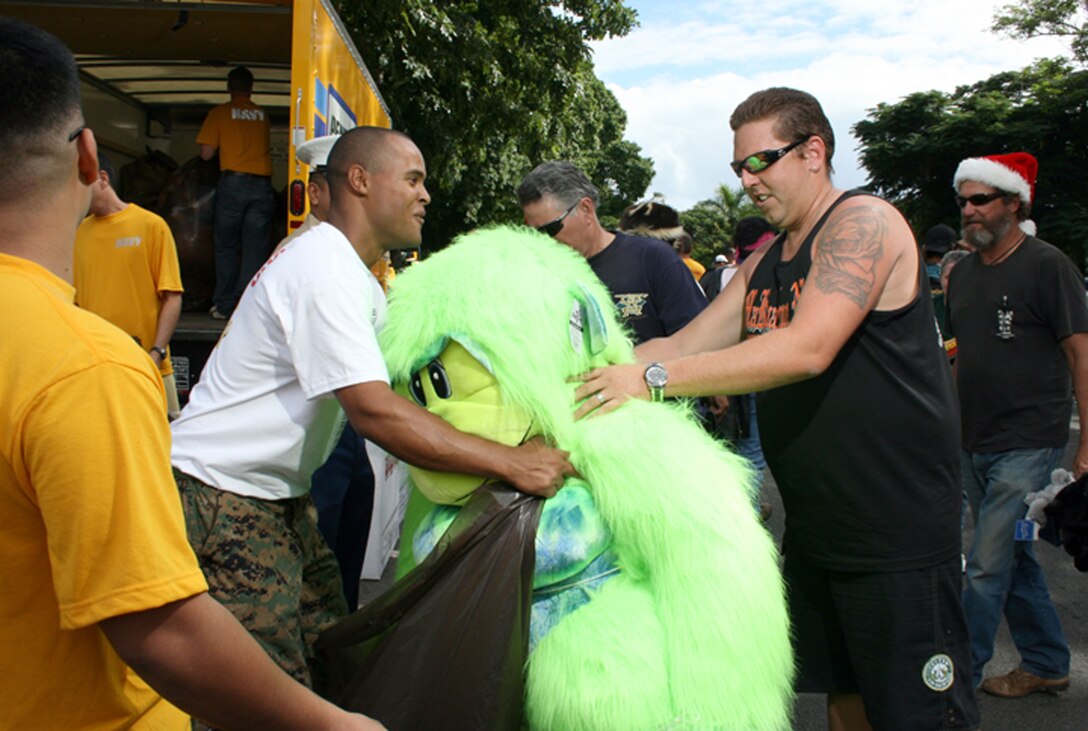 Keoni Vaughn of Hui o Halawa, the bike club of Halawa Prison Corrections Officers, donates a lime green ape that he, his wife and his 16-year old foster daughter, won at Dave & Busters Restaurant.  More than 5,000 motorcyclists participated in this year's Toys for Tots benefit and collected thousands of toys for Hawaii's less-fortunate children.