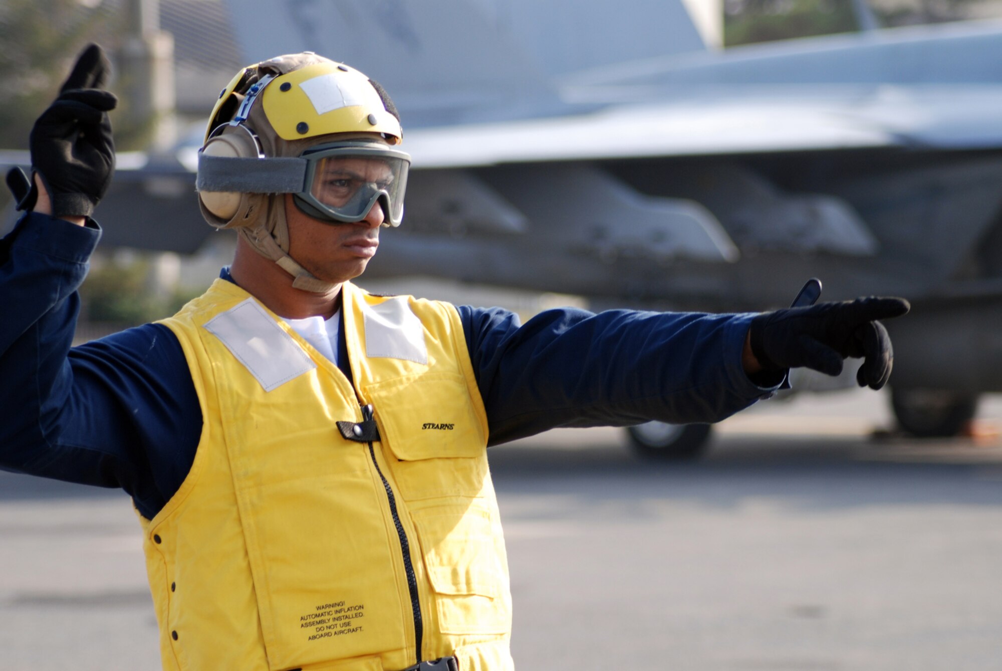 MISAWA AIR BASE, Japan -- Petty Officer 2nd Class Jason Williams, Naval Air Facility Misawa flight support crew member, directs the movement of an F/A-18E Super Hornet pilot prior to take-off. Four of the jets, from NAF Atsugi-based Strike Fighter Squadron 27, stopped at the base in Northern Japan as part of a routine training mission Dec. 4, 2008. (U.S. Navy photo by Chief Petty Officer Brian Naranjo)