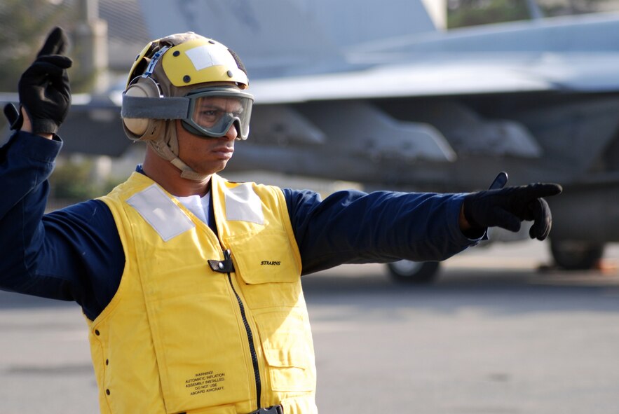 MISAWA AIR BASE, Japan -- Petty Officer 2nd Class Jason Williams, Naval Air Facility Misawa flight support crew member, directs the movement of an F/A-18E Super Hornet pilot prior to take-off. Four of the jets, from NAF Atsugi-based Strike Fighter Squadron 27, stopped at the base in Northern Japan as part of a routine training mission Dec. 4, 2008. (U.S. Navy photo by Chief Petty Officer Brian Naranjo)
