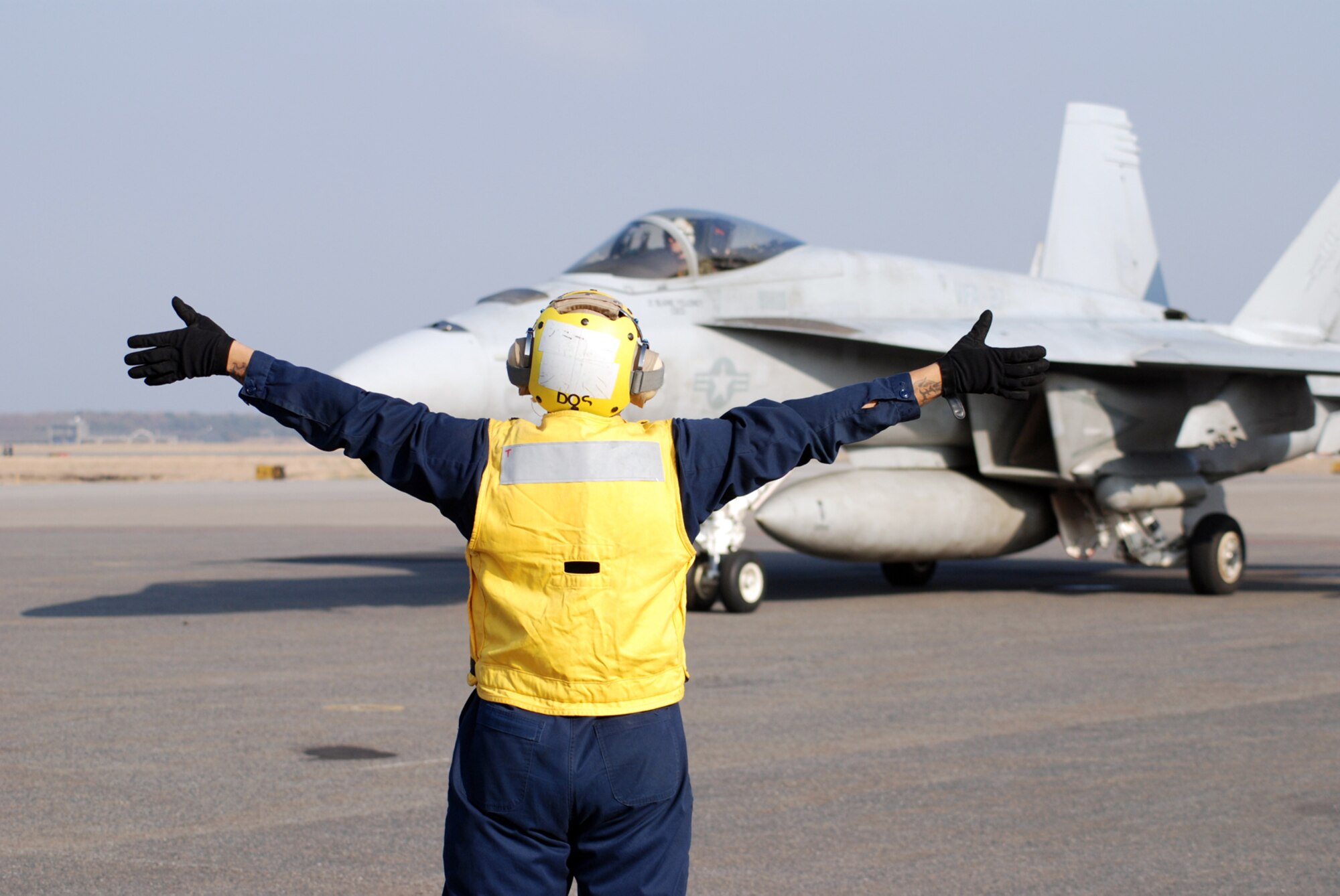 MISAWA AIR BASE, Japan -- Petty Officer 2nd Class Jason Williams, Naval Air Facility Misawa flight support crew member, directs the movement of an F/A-18E Super Hornet pilot prior to take-off. Four of the jets, from NAF Atsugi-based Strike Fighter Squadron 27, stopped at the base in Northern Japan as part of a routine training mission Dec. 4, 2008. (U.S. Navy photo by Chief Petty Officer Brian Naranjo)