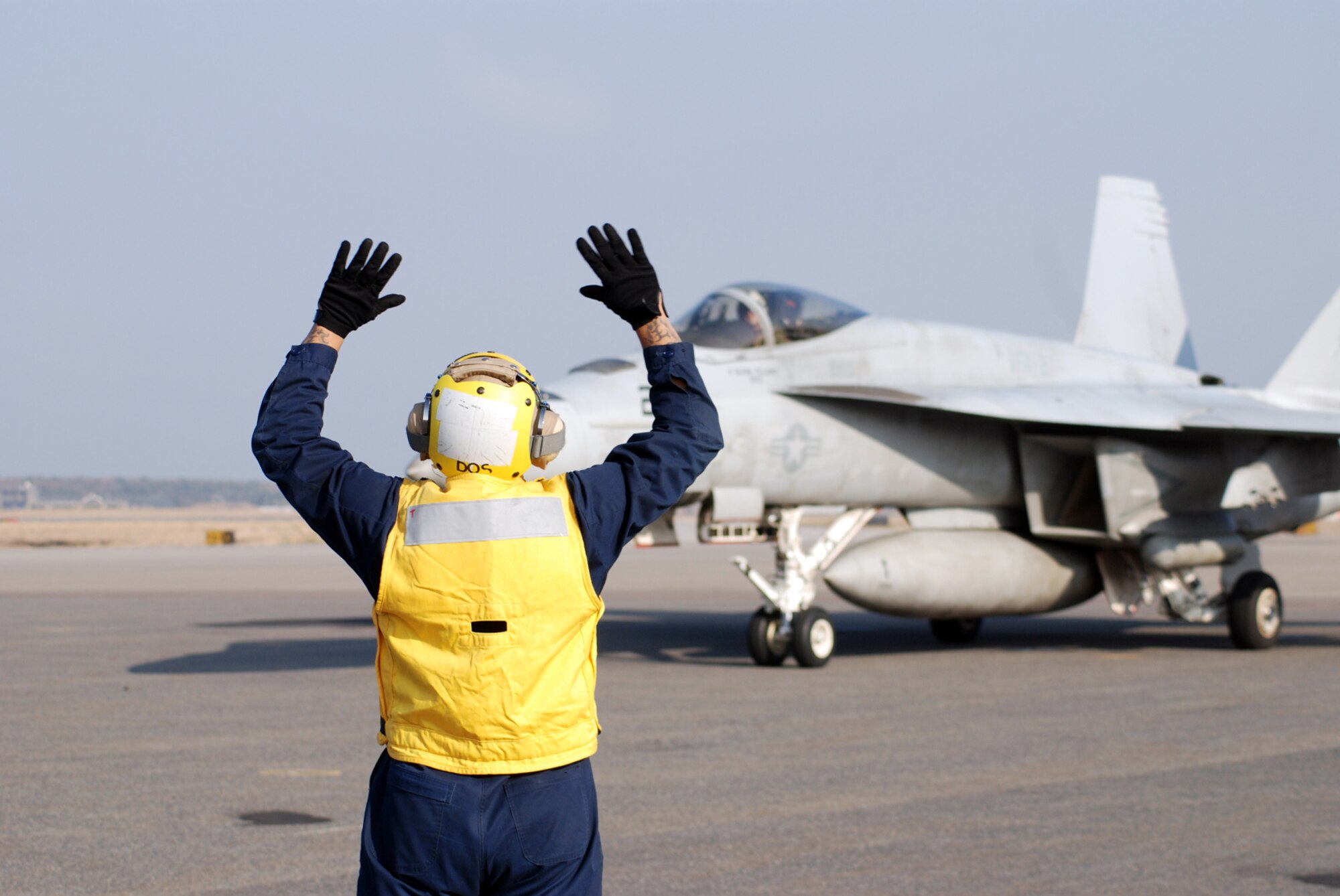 MISAWA AIR BASE, Japan -- Petty Officer 2nd Class Jason Williams, Naval Air Facility Misawa flight support crew member, directs the movement of an F/A-18E Super Hornet pilot prior to take-off. Four of the jets, from NAF Atsugi-based Strike Fighter Squadron 27, stopped at the base in Northern Japan as part of a routine training mission Dec. 4, 2008. (U.S. Navy photo by Chief Petty Officer Brian Naranjo)